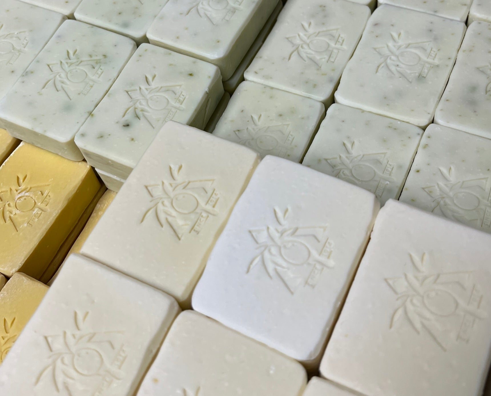 Handmade Greek olive oil soap bars in natural shades, embossed with Laconic Foods logo