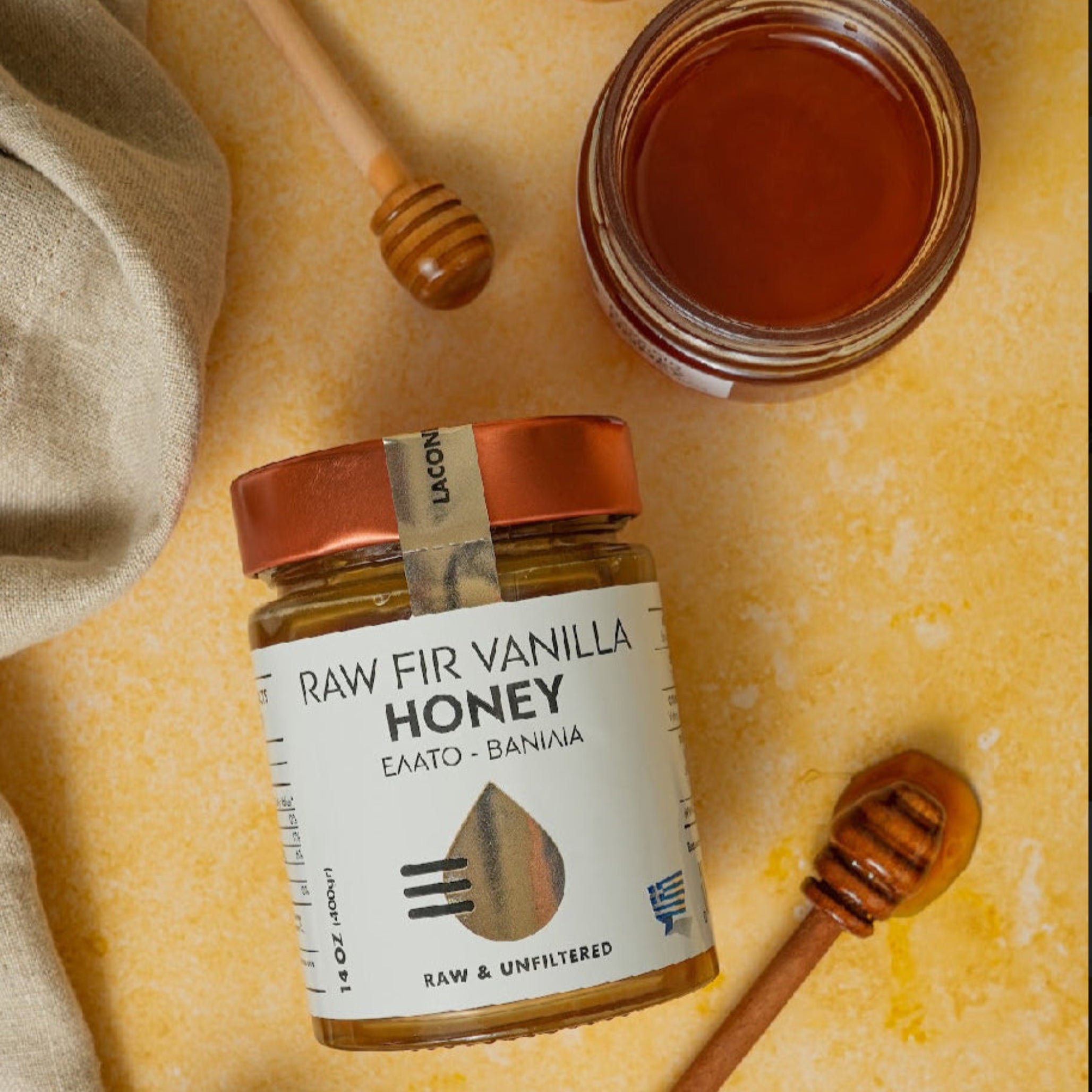 Flat lay of Raw Fir Vanilla Honey with open jar, wooden dipper, and rustic background