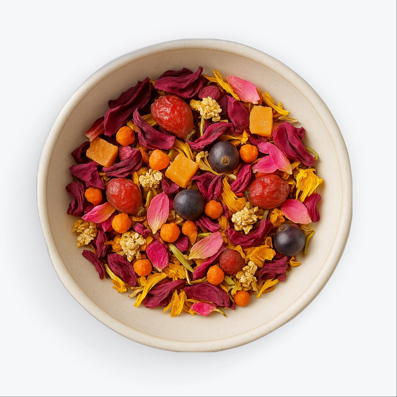 Loose leaf blend of Electra tea with rose petals, orange cubes, elderflower, and juniper berries in a ceramic bowl