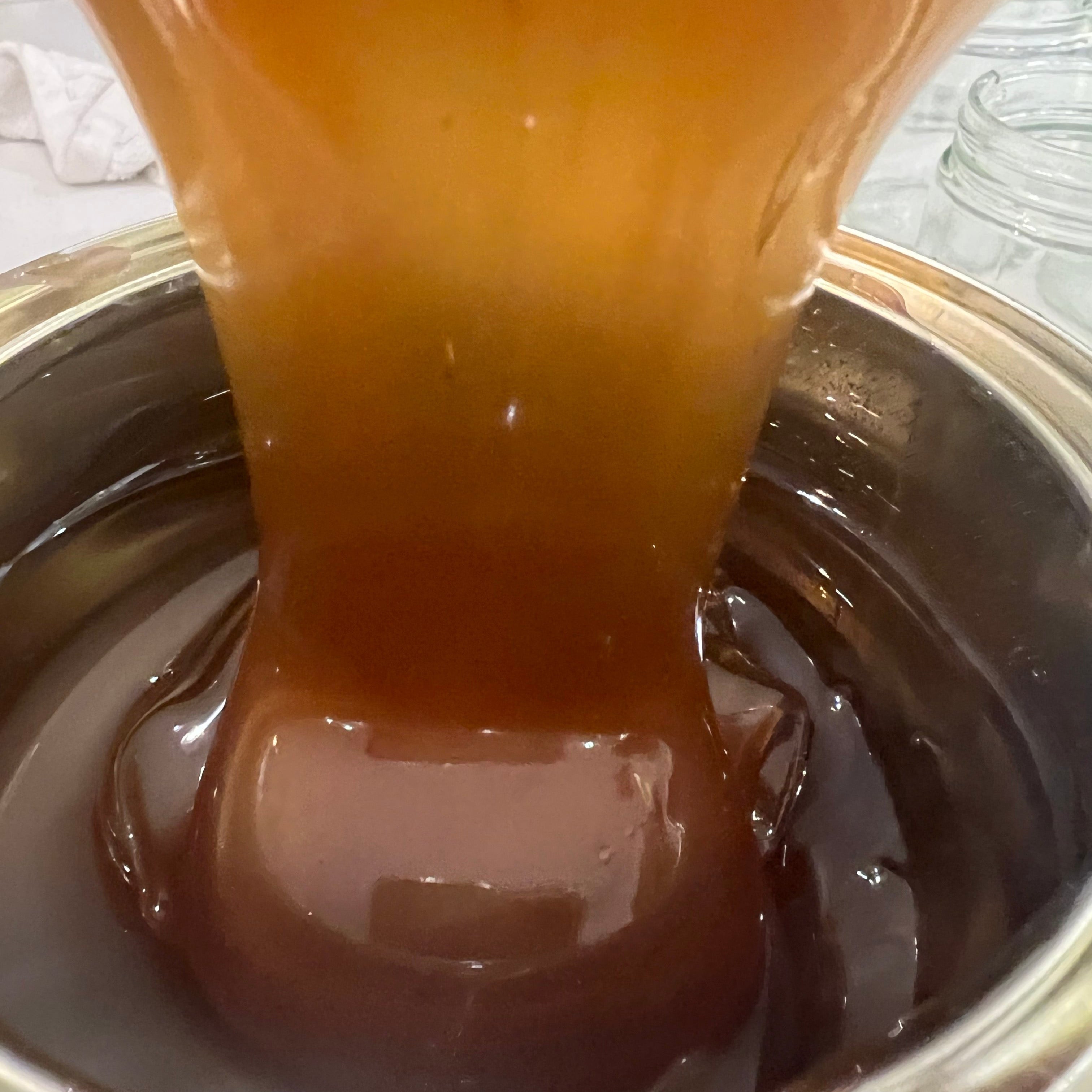 Freshly harvested Vanilla Fir Honey pouring into stainless vat during processing