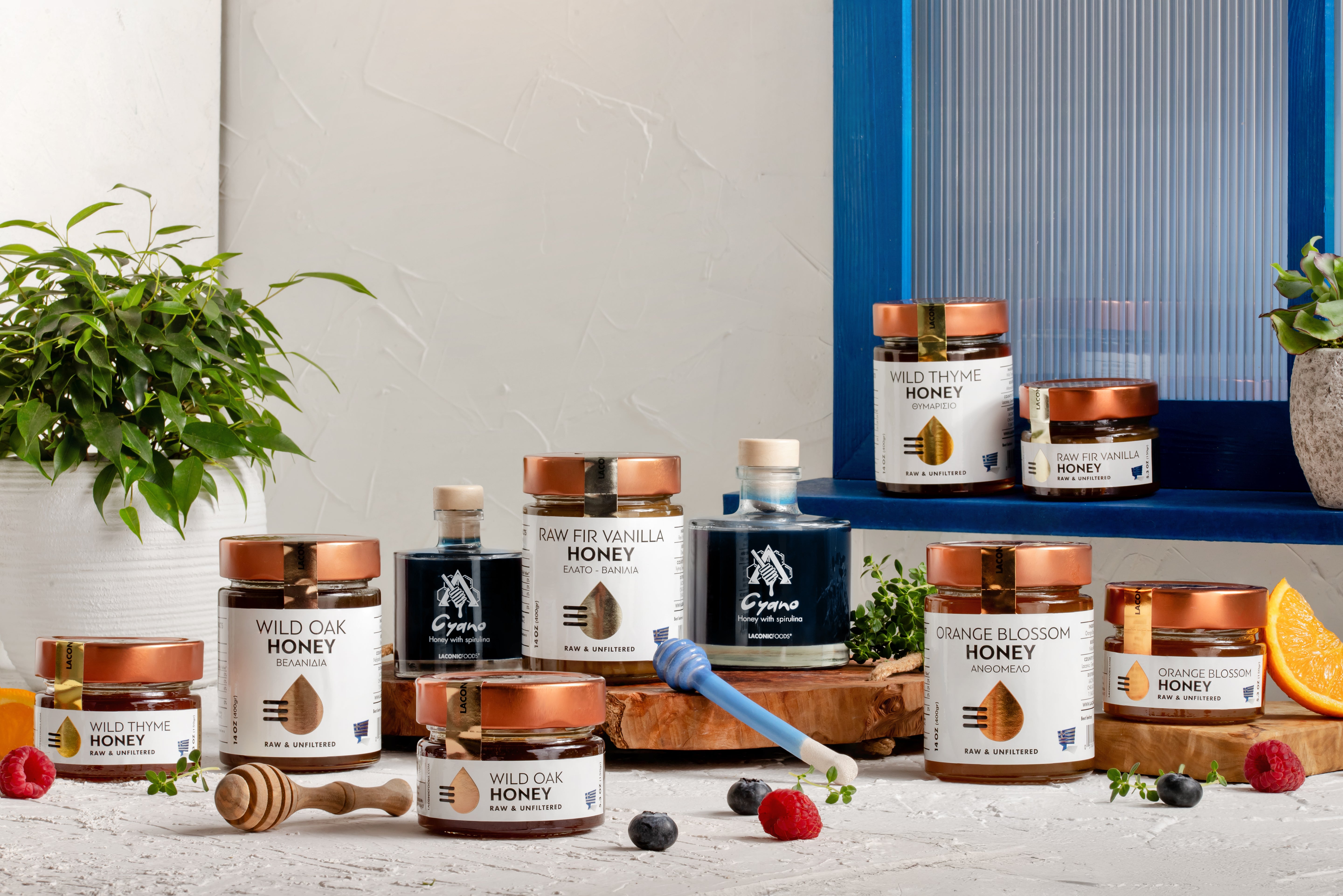 Laconic Foods Greek raw and unfiltered honey collection including Wild Thyme, Oak, Orange Blossom, and Vanilla Fir honeys with honey dippers