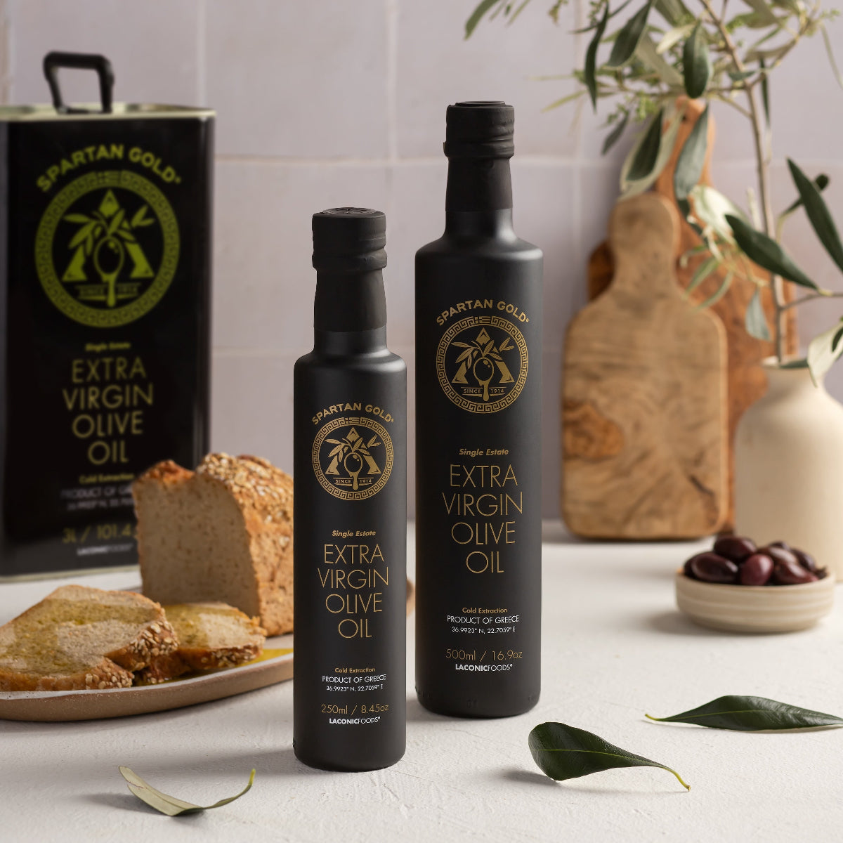 Laconic Foods — Award-Winning Greek Extra Virgin Olive Oil bottles (250ml and 500ml) with bread and olives