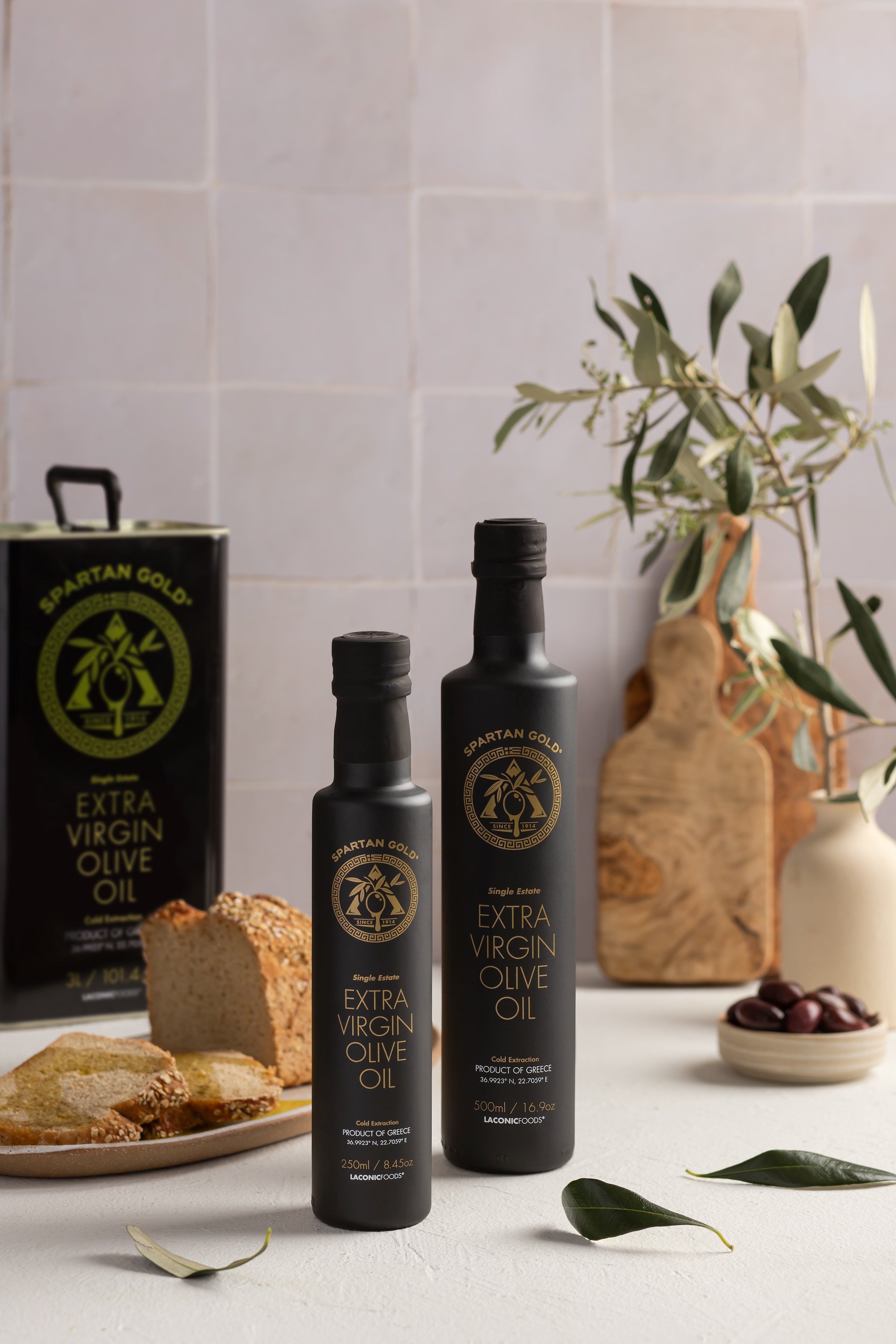 Laconic 3L EVOO tin on kitchen counter with bread, olives, and vegetables