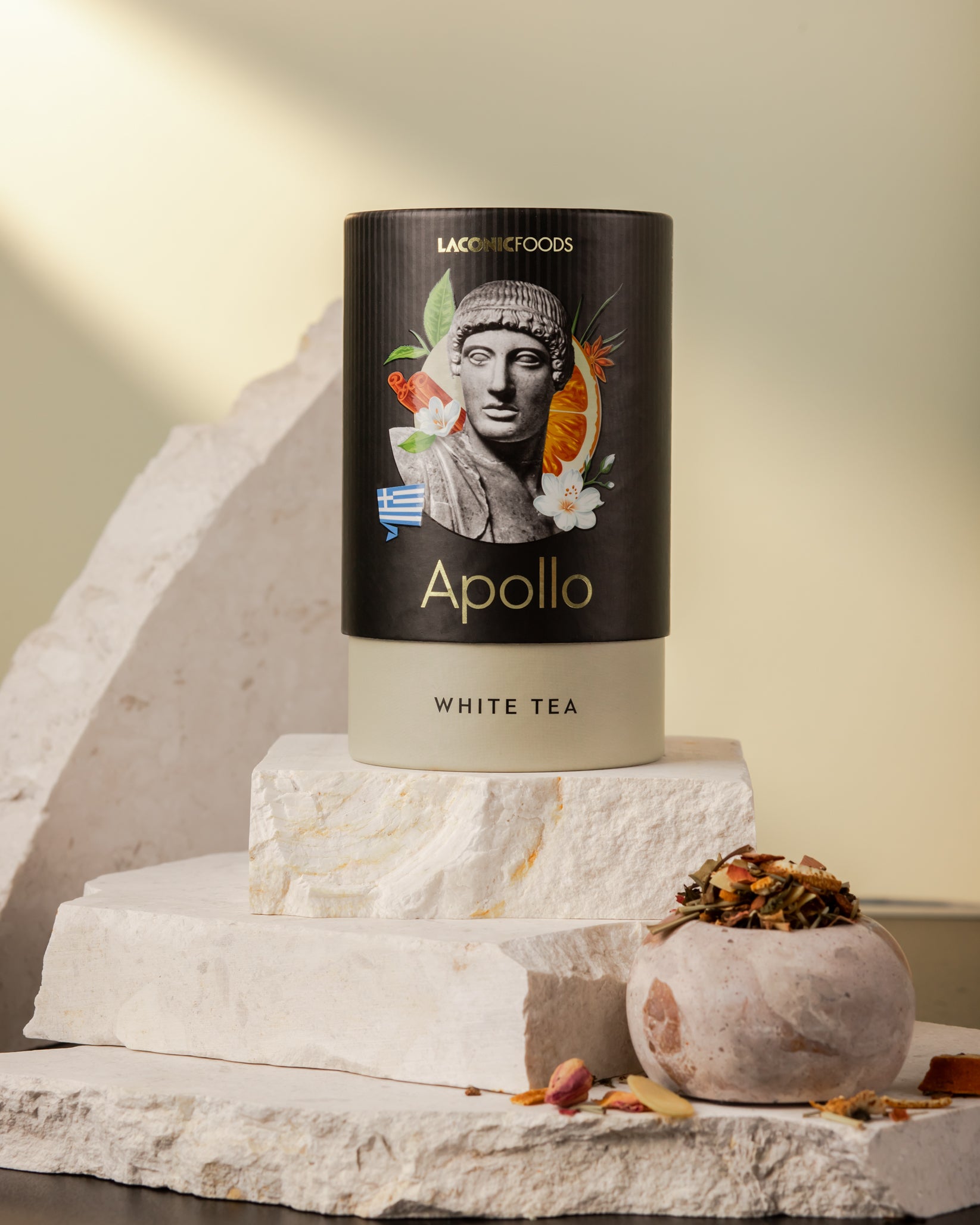 Front view of Laconic Foods Apollo White Tea canister – premium Greek loose leaf white tea styled on marble stones with warm sunlight.