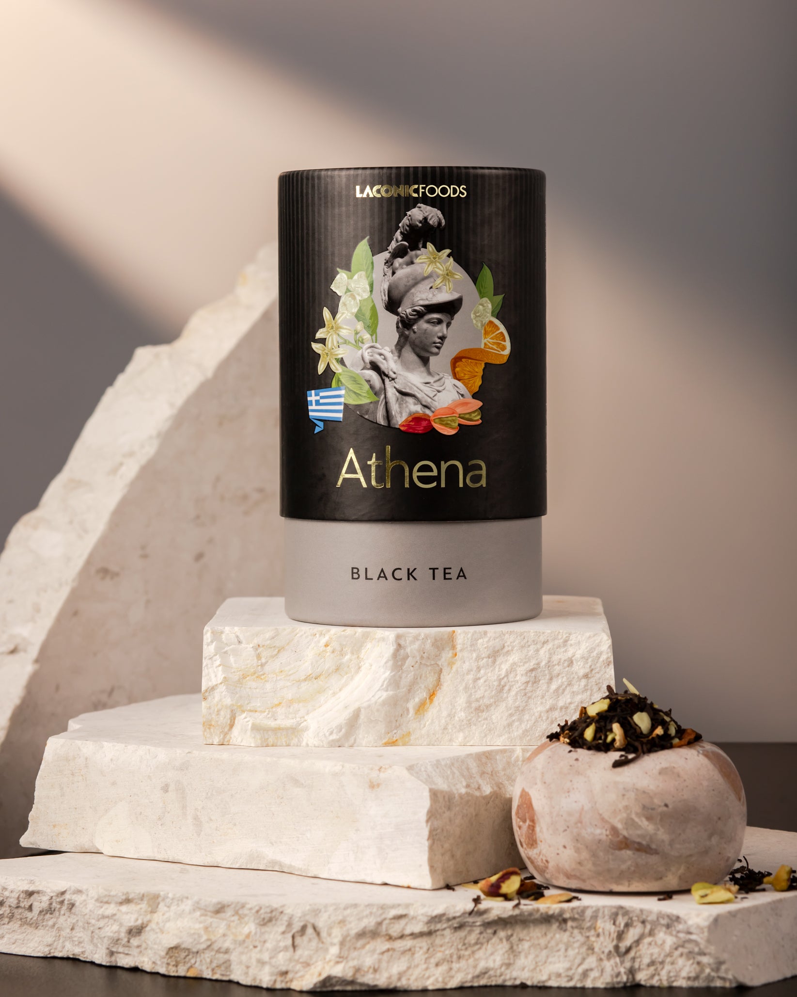 Front view of Laconic Foods Athena Black Tea canister – premium Greek loose leaf black tea styled on marble stones with soft neutral lighting.