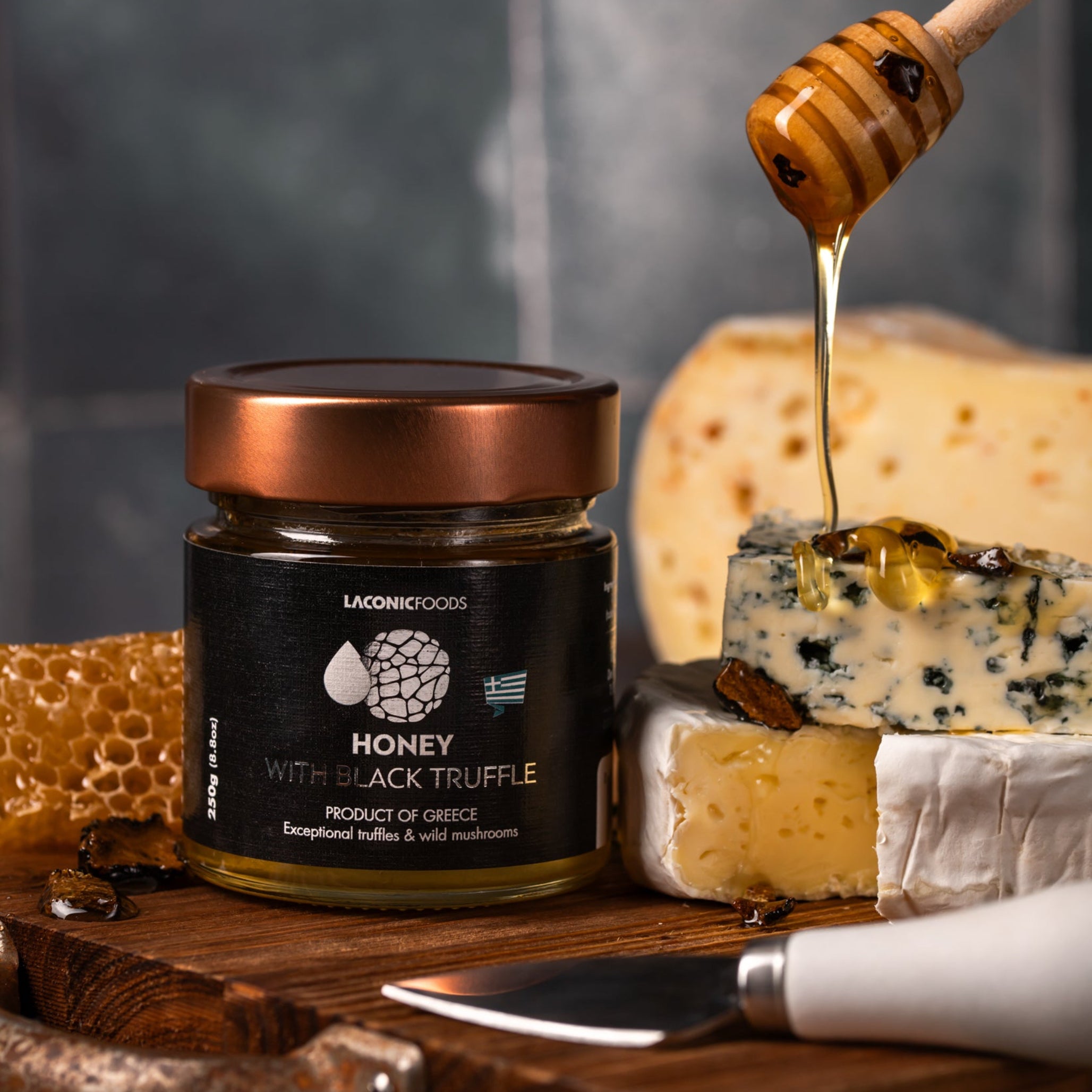 Laconic Foods Honey with Black Truffle 250g paired with gourmet cheeses, honey drizzle, and truffle pieces – elegant serving suggestion from Greece.