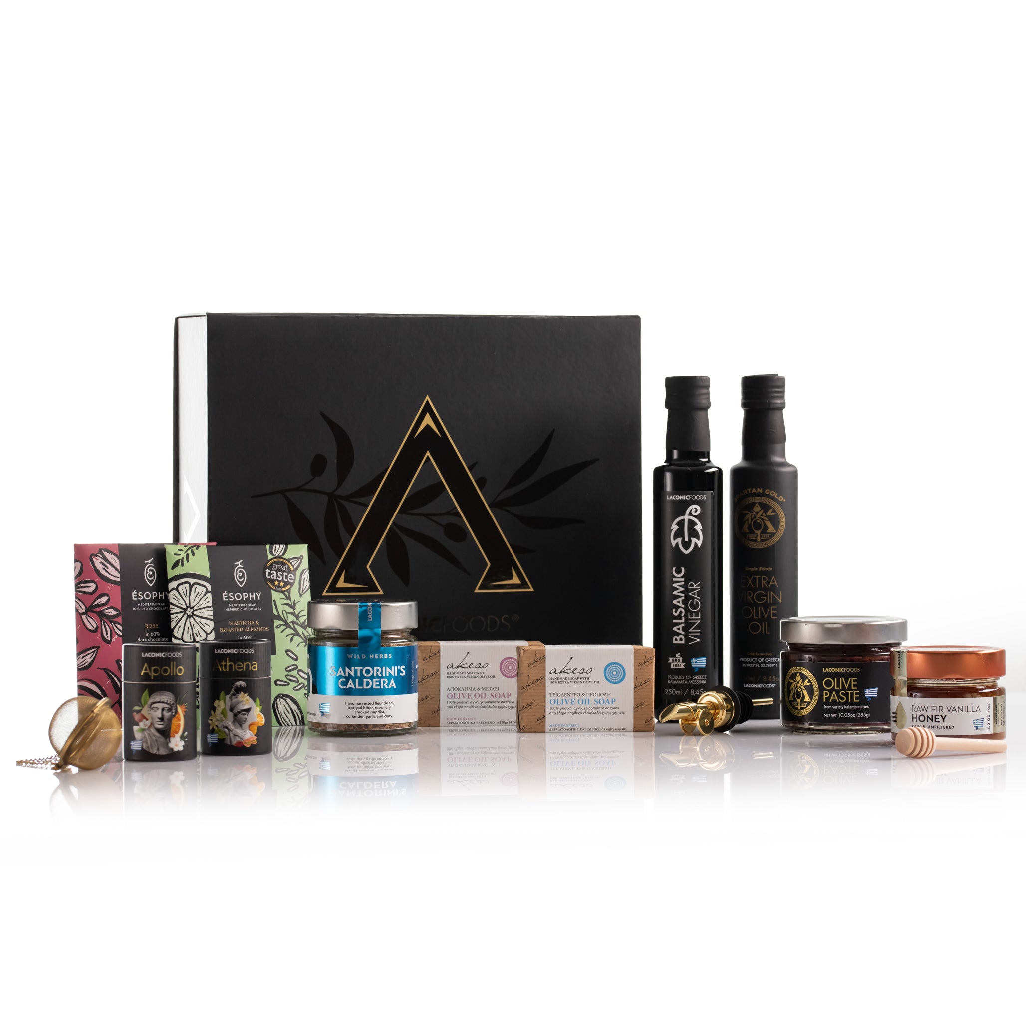 Laconic Foods luxury Greek gourmet gift set display with extra virgin olive oil, vinegar, honey, olive paste, teas, chocolates, soaps, spice blend, and premium black gift box