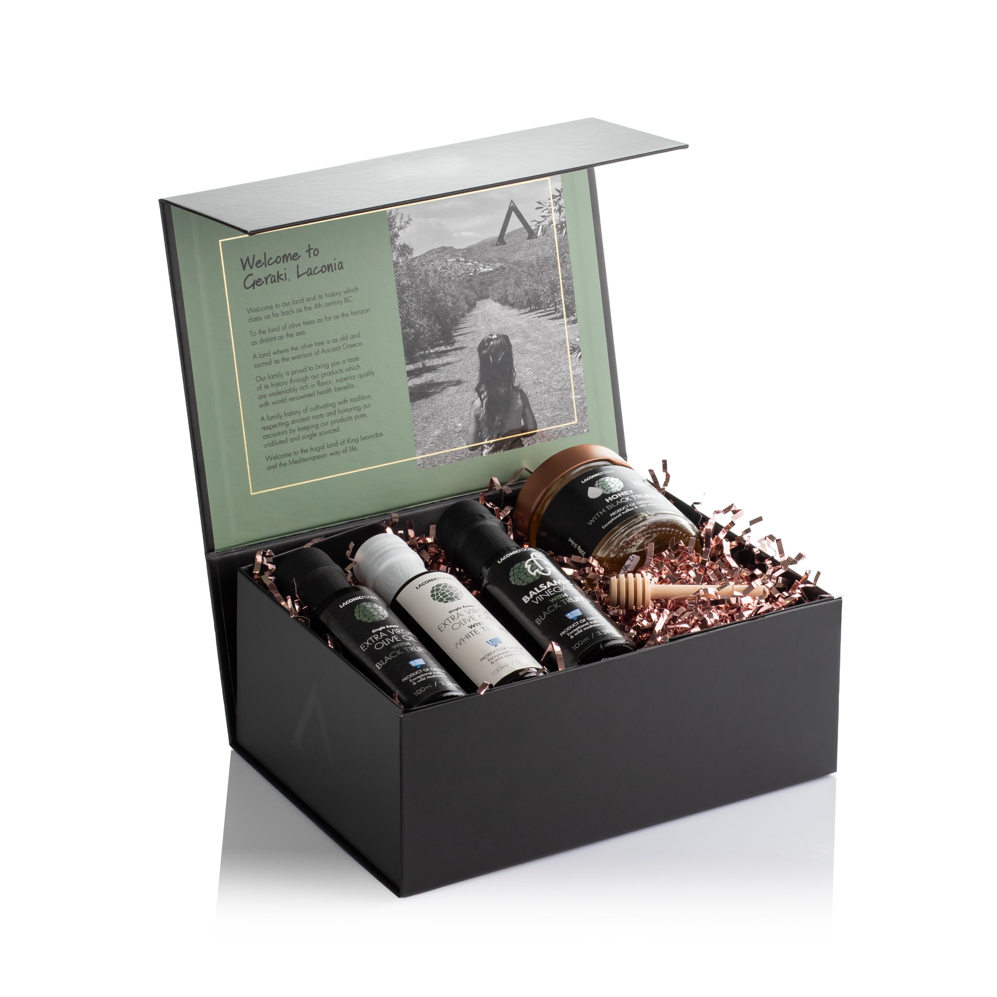 Laconic Foods Truffle Gift Box open to reveal black and white truffle olive oils, truffle honey, balsamic vinegar, and wooden honey dipper in a premium black box.
