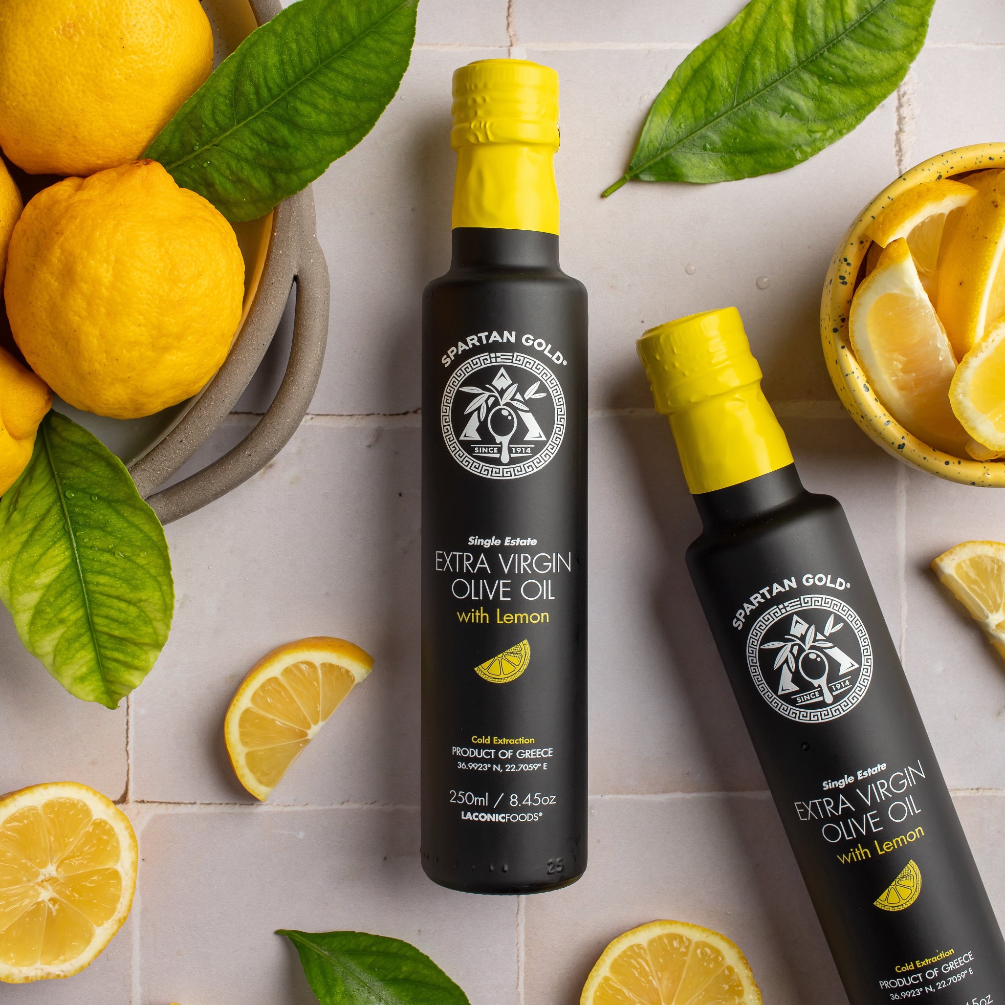 Flat lay of Lemon Infused Extra Virgin Olive Oil bottles with fresh lemons and leaves