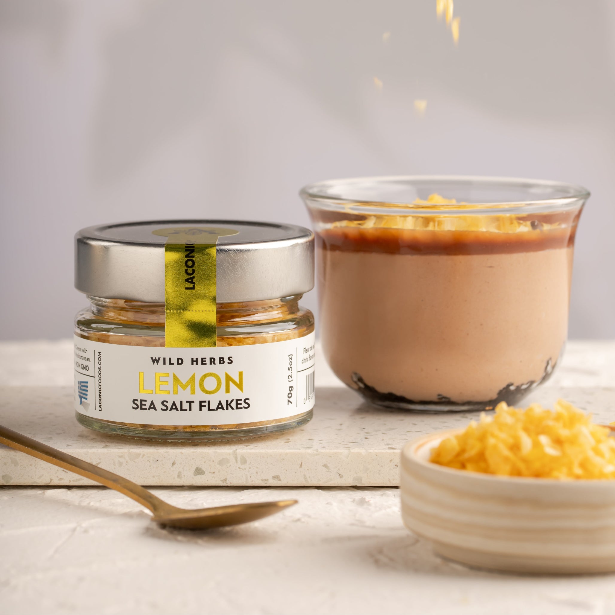 Lemon Sea Salt Flakes being sprinkled over a citrus dessert for a gourmet finishing touch