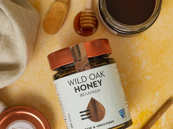 Top view of Wild Oak Honey jar with dipper on warm rustic background