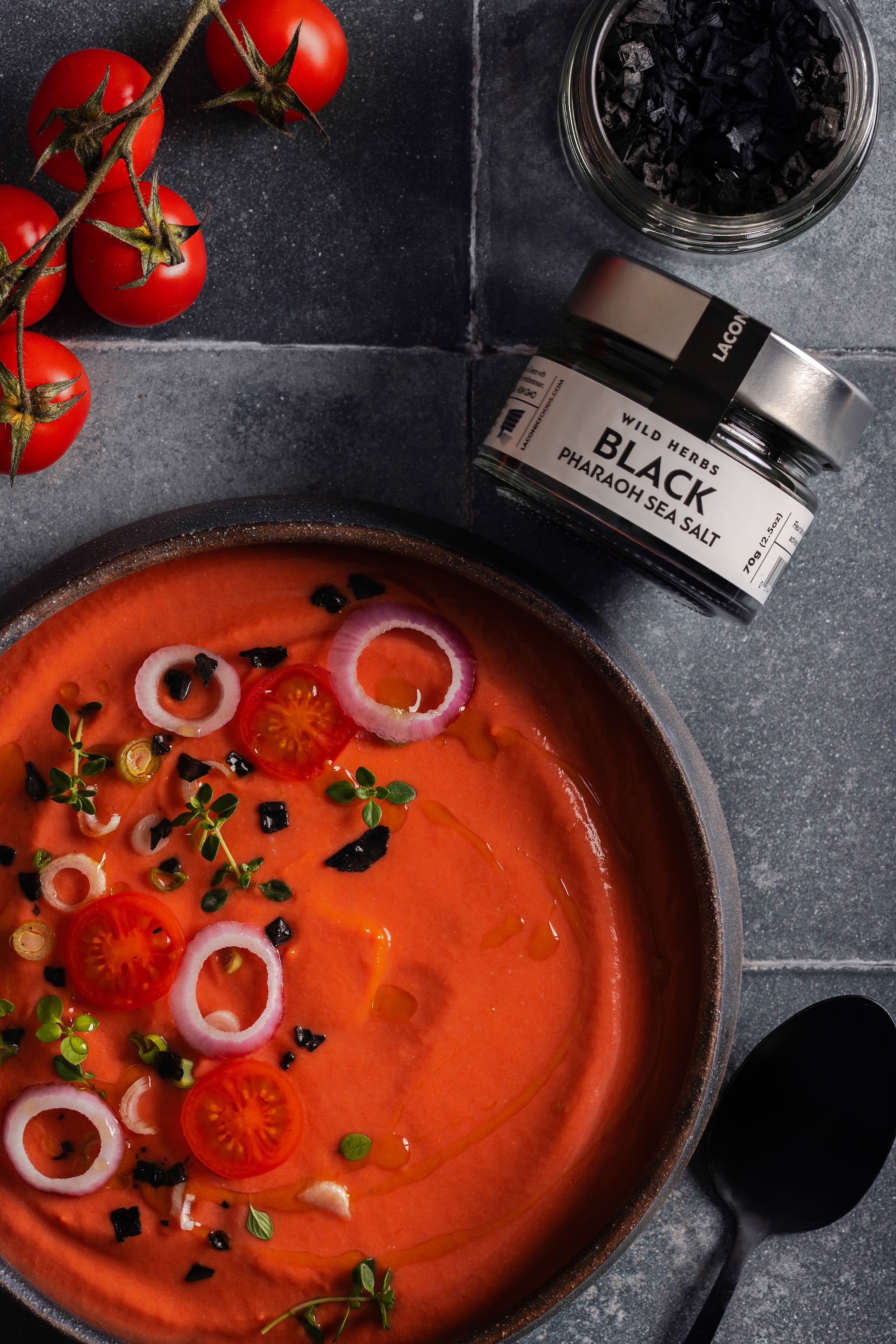 Black Pharaoh Sea Salt sprinkled on gazpacho with cherry tomatoes and red onions