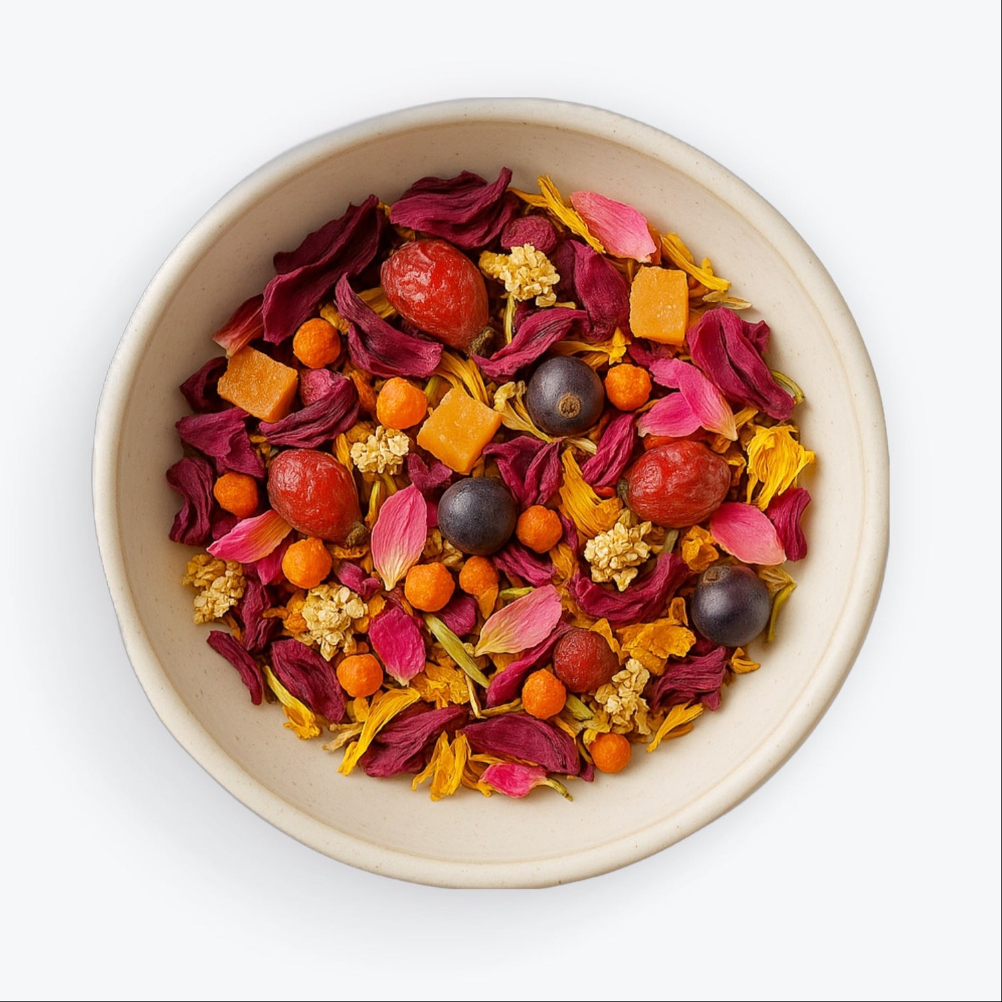 Loose leaf blend of Electra tea with rose petals, orange cubes, elderflower, and juniper berries in a ceramic bowl