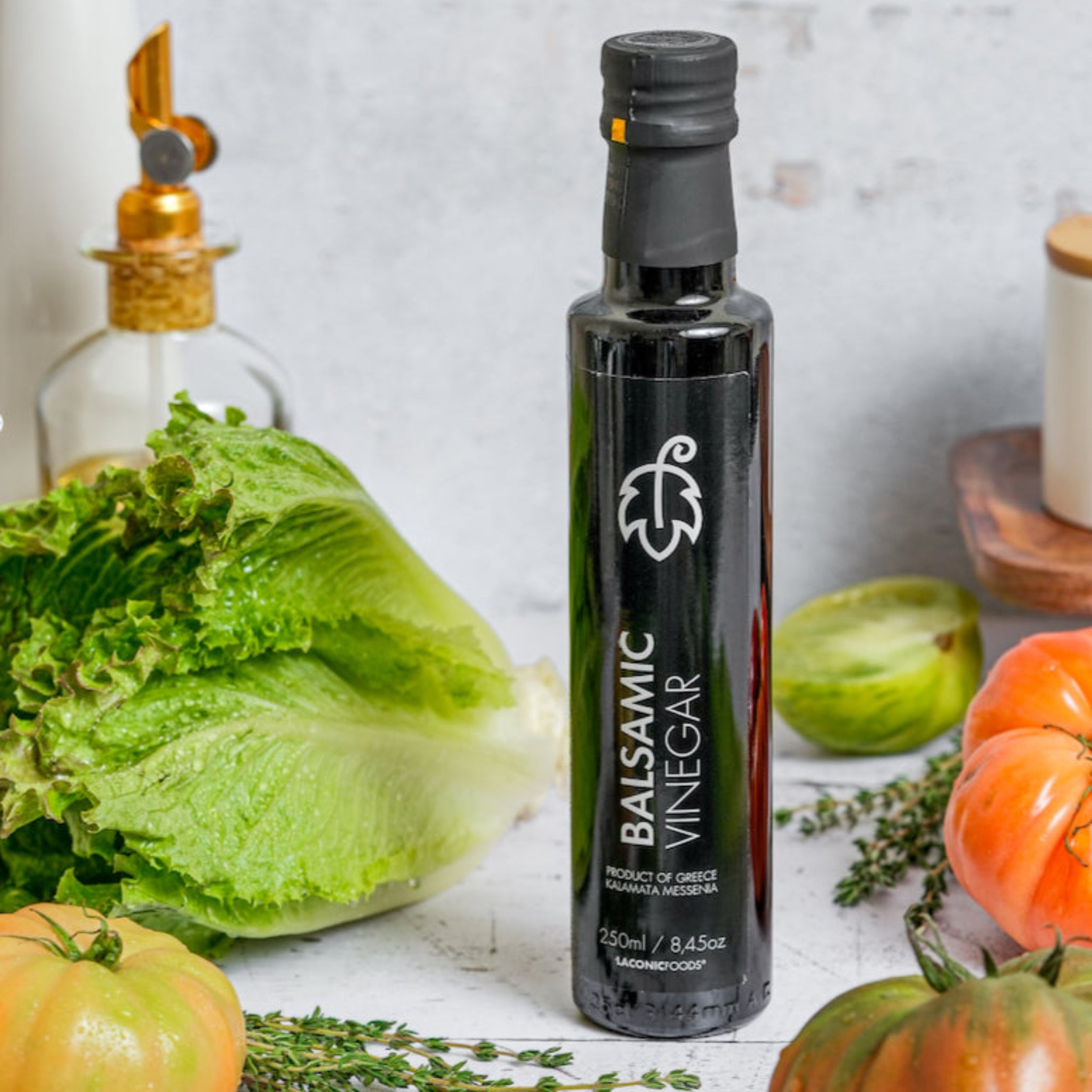 Greek balsamic vinegar surrounded by fresh vegetables – perfect for salads and dressings