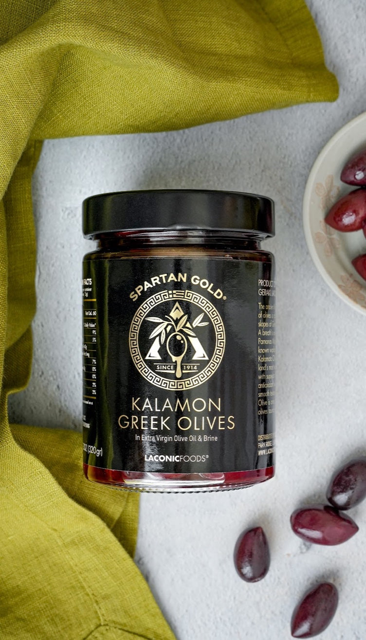 Laconic Foods Kalamon Greek Olives jar with green napkin and scattered olives