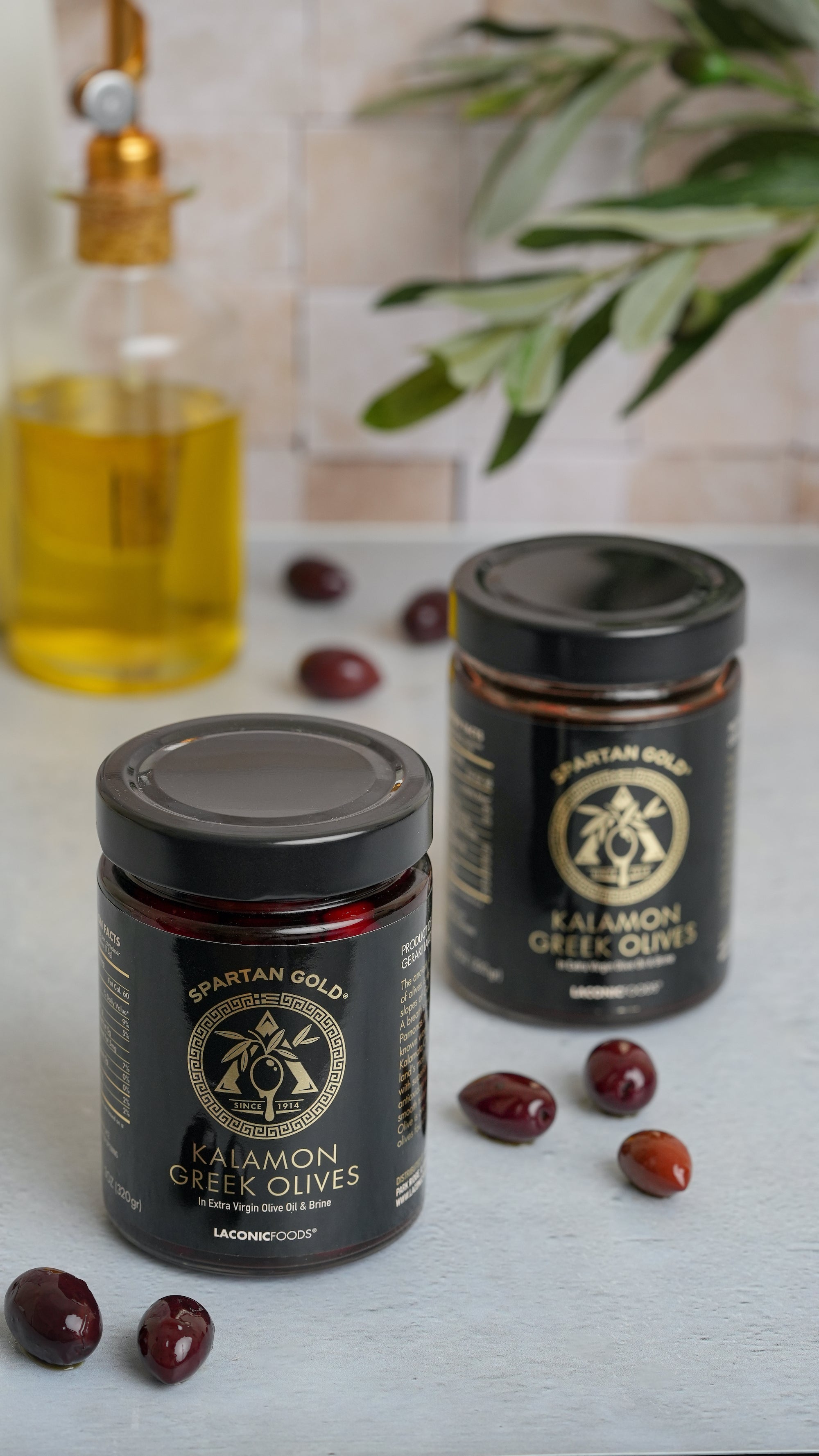Two jars of Laconic Foods Kalamon Greek Olives with olives on kitchen counter