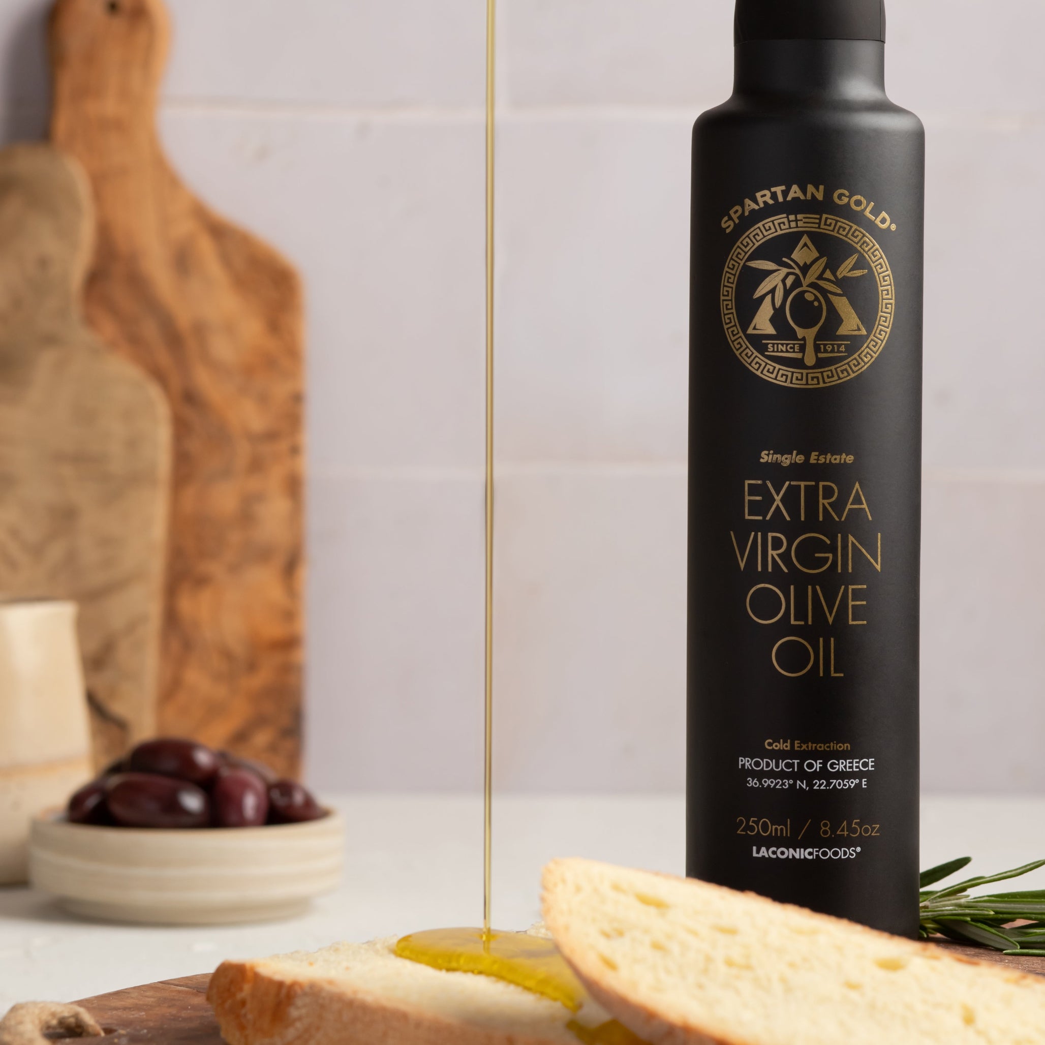 Laconic Foods Extra Virgin Olive Oil being poured on bread – rich and golden color