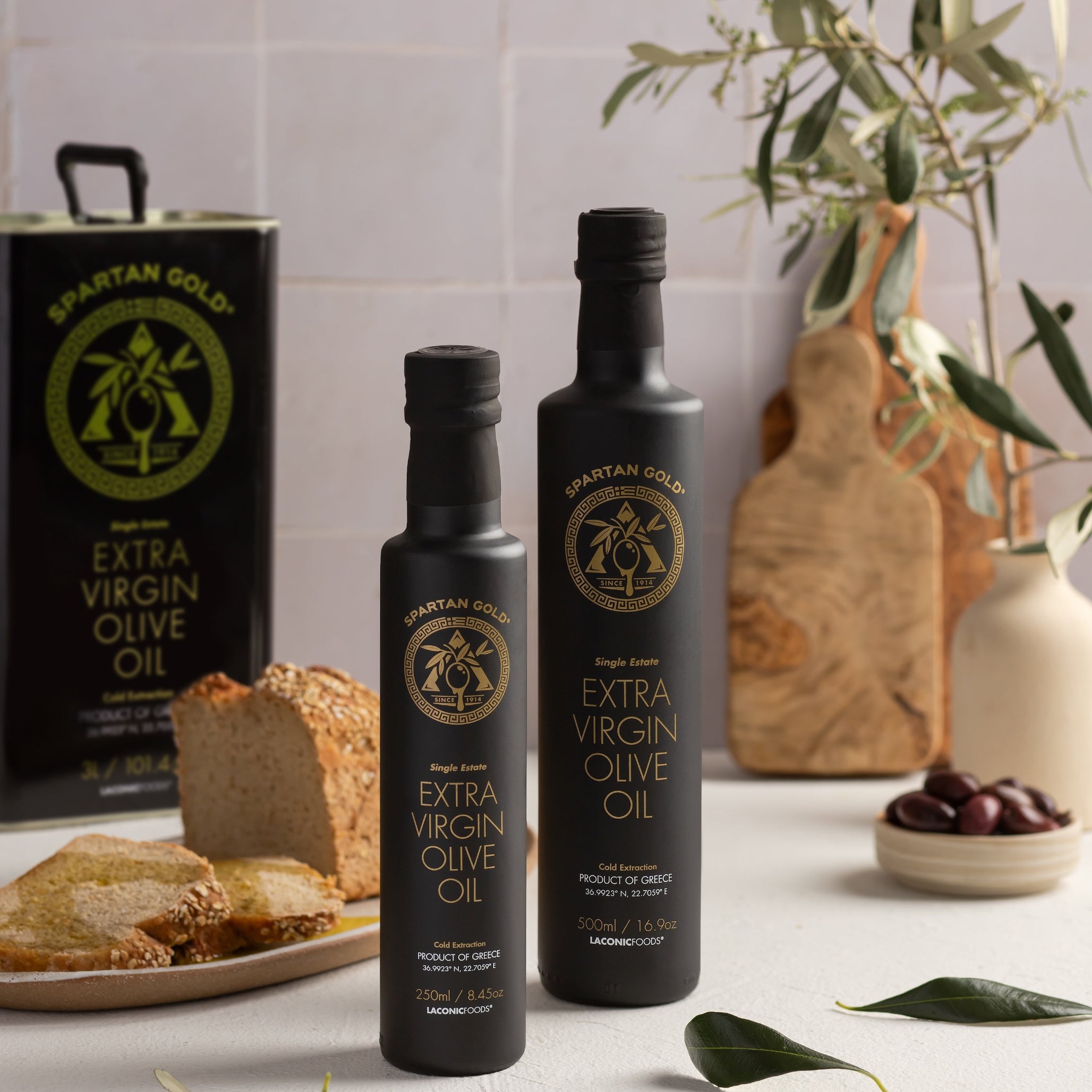 Laconic 3L EVOO tin on kitchen counter with bread, olives, and vegetables