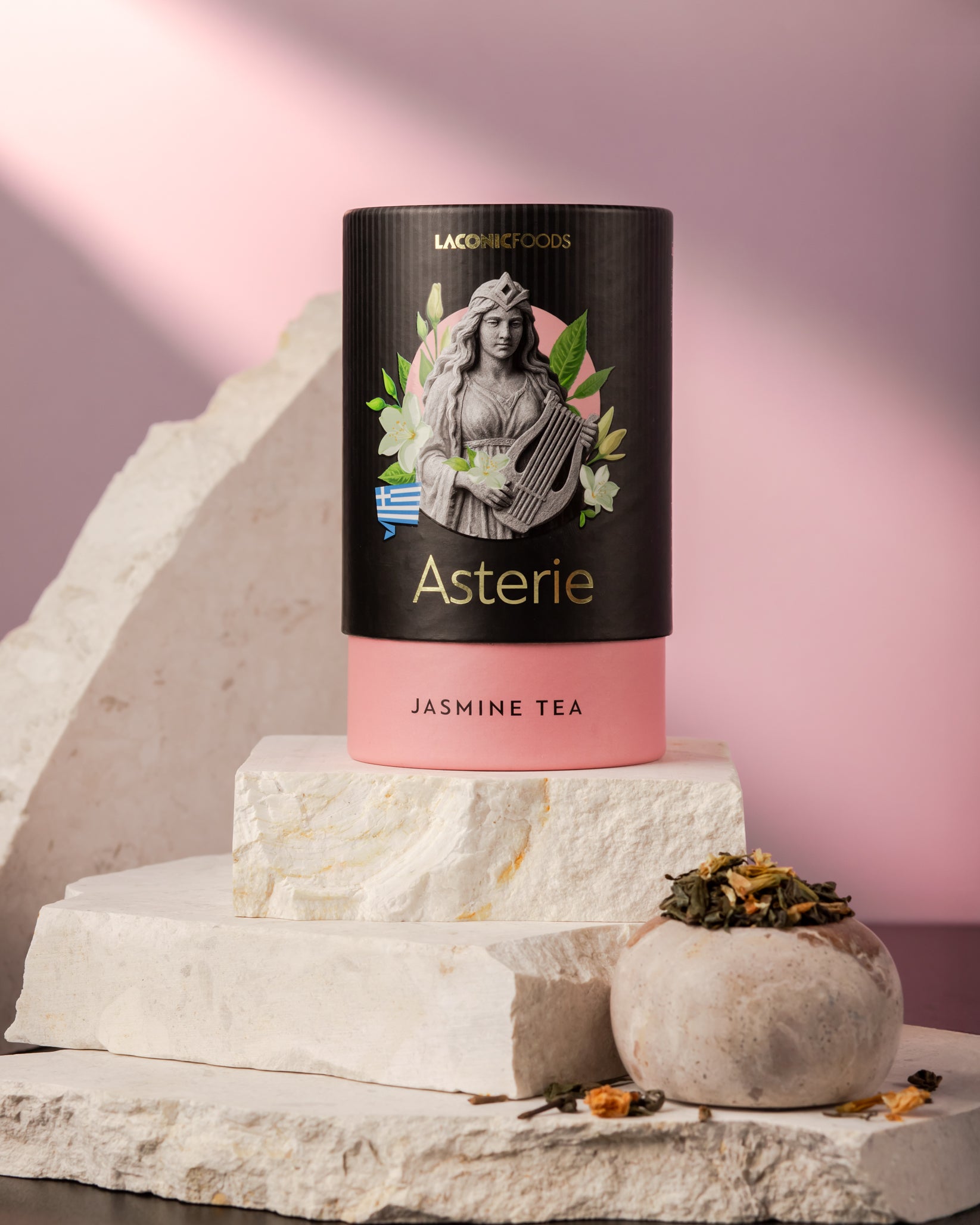 Front view of Laconic Foods Asterie Jasmine Tea canister – elegant Greek loose leaf tea with jasmine, styled on marble with soft pink background.