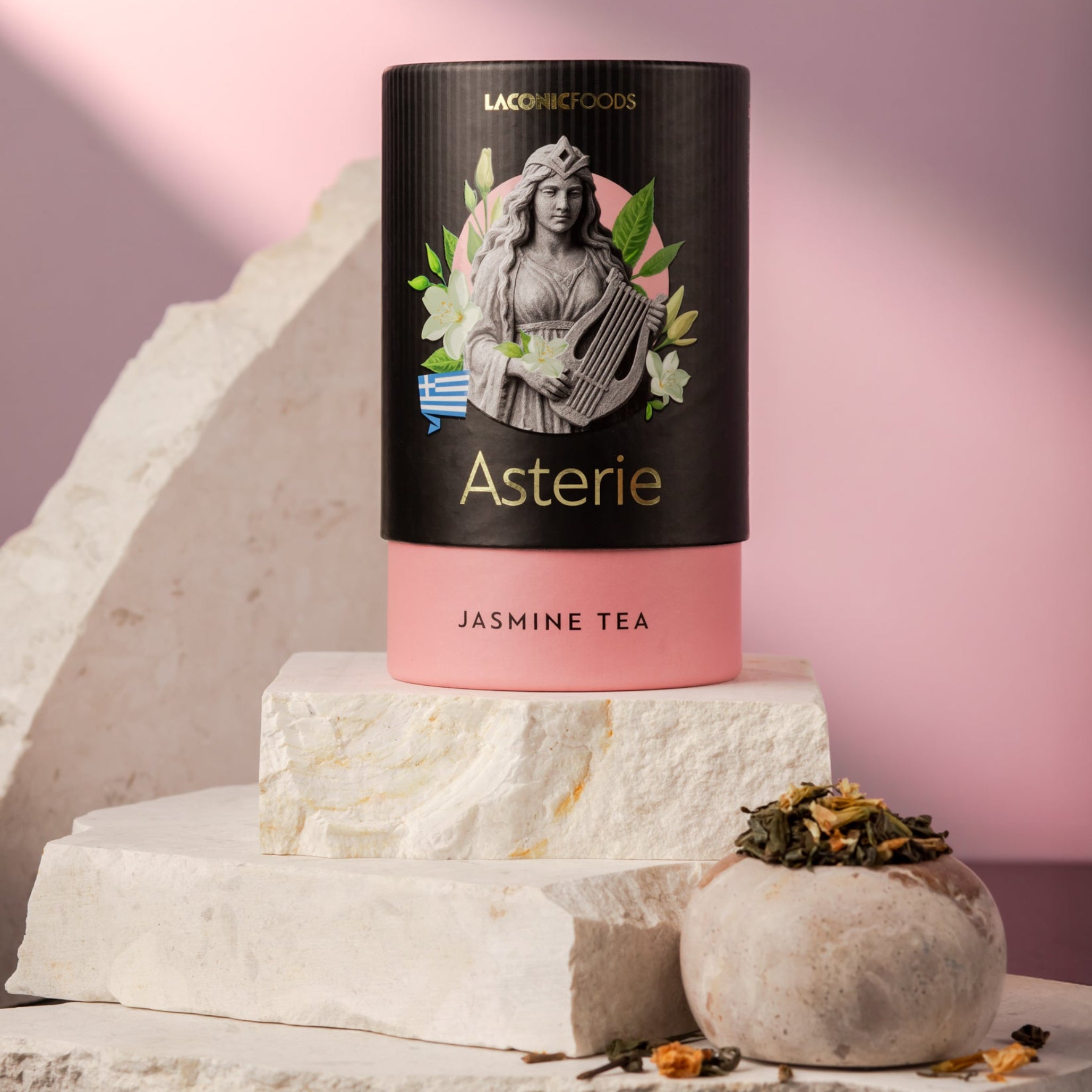 Front view of Laconic Foods Asterie Jasmine Tea canister – elegant Greek loose leaf tea with jasmine, styled on marble with soft pink background.