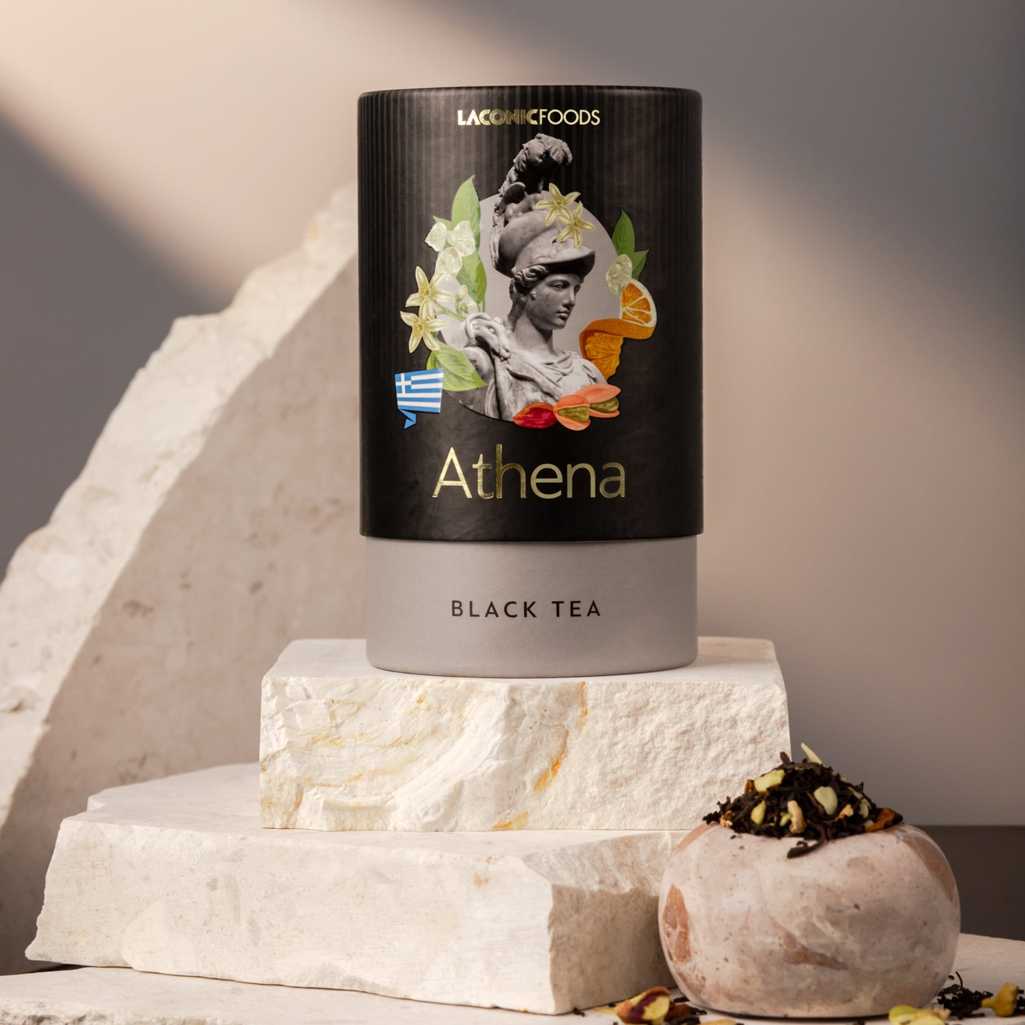 Front view of Laconic Foods Athena Black Tea canister – premium Greek loose leaf black tea styled on marble stones with soft neutral lighting.