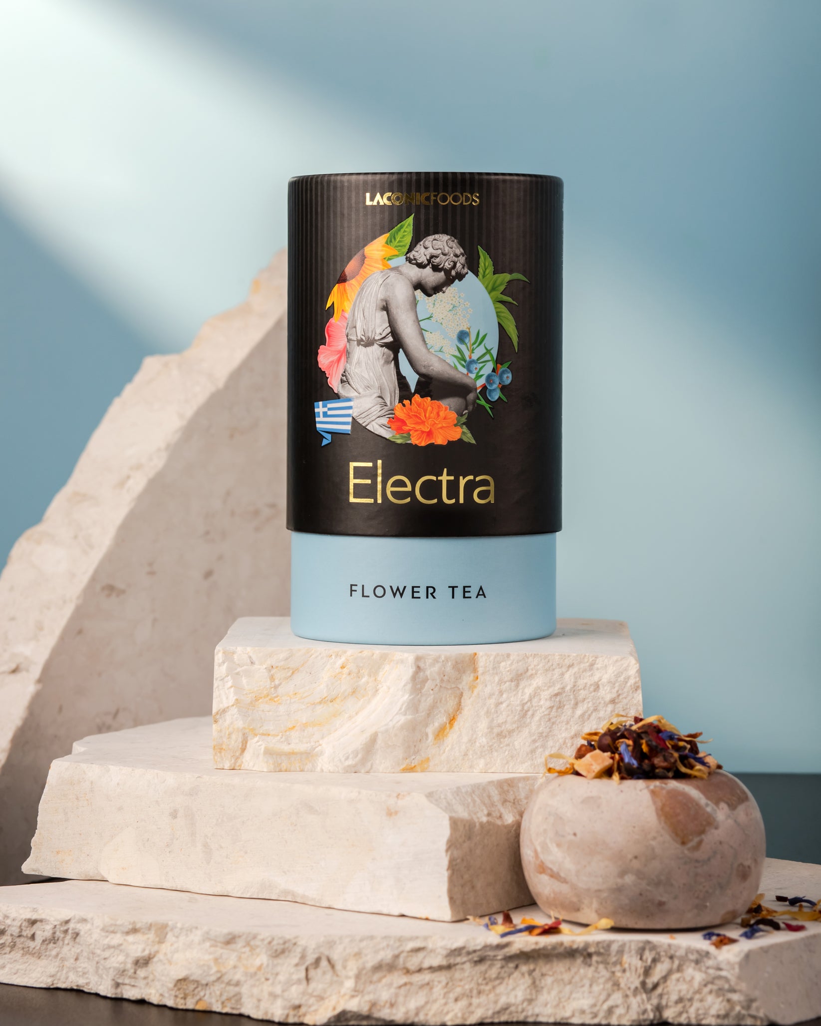 Front view of Laconic Foods Electra Flower Tea canister – premium Greek loose leaf flower tea styled on marble stones with blue background.