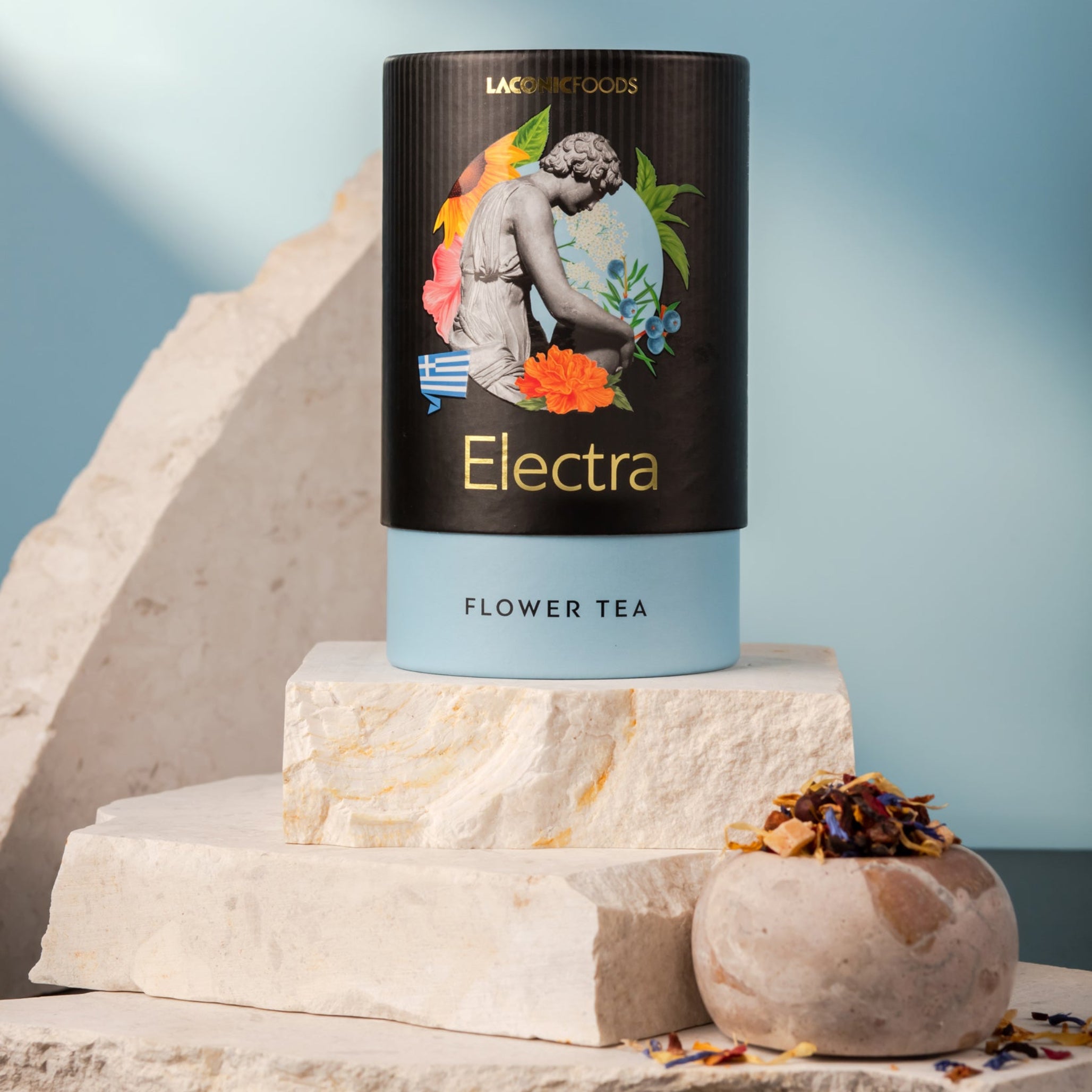 Front view of Laconic Foods Electra Flower Tea canister – premium Greek loose leaf flower tea styled on marble stones with blue background.