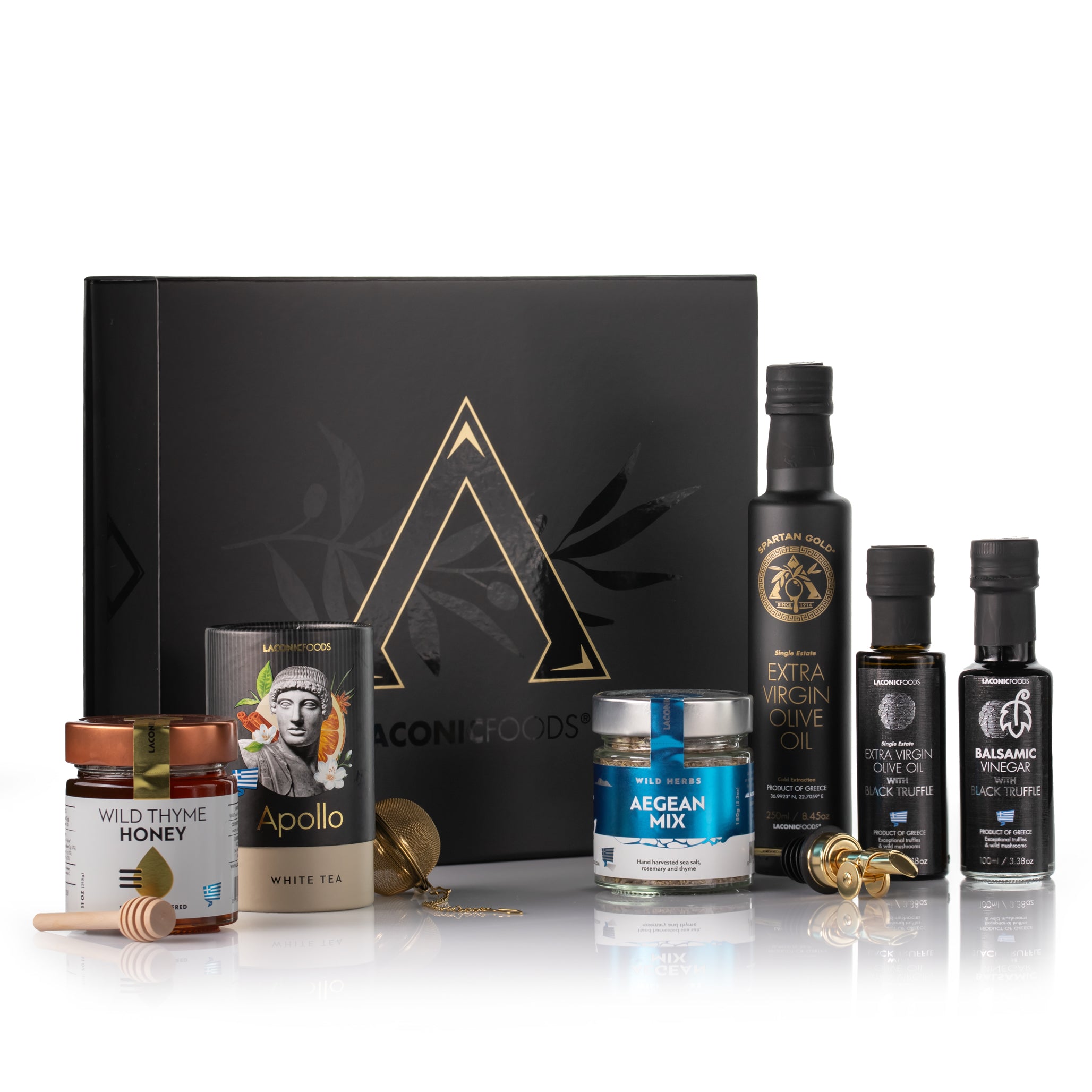 Laconic Foods Gourmet Experience Gift Box products displayed with black gift box, Greek olive oil, truffle vinegar, wild thyme honey, Apollo tea, and Aegean spice mix.