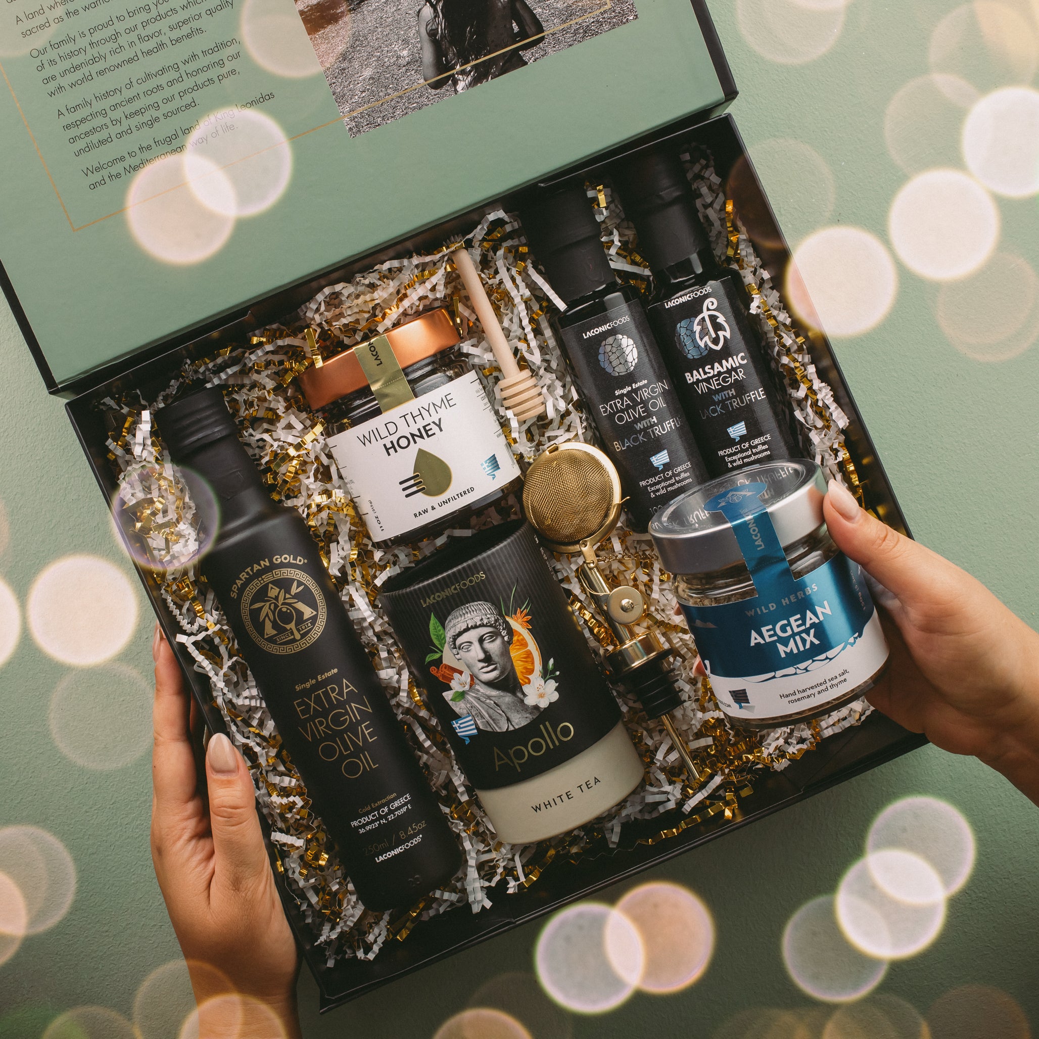 Laconic Foods gourmet gift box featuring Wild Thyme Honey, extra virgin olive oil, black truffle balsamic vinegar, Apollo tea, and Aegean herb mix in premium holiday packaging.