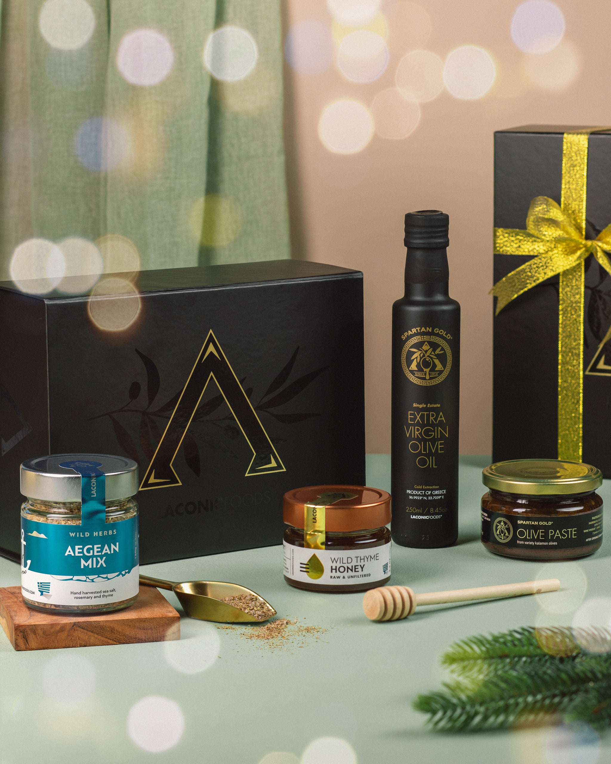 Festive Laconic Foods holiday gift box featuring Greek olive oil, honey, olive paste, and Aegean spice blend with ribbon and holiday decor