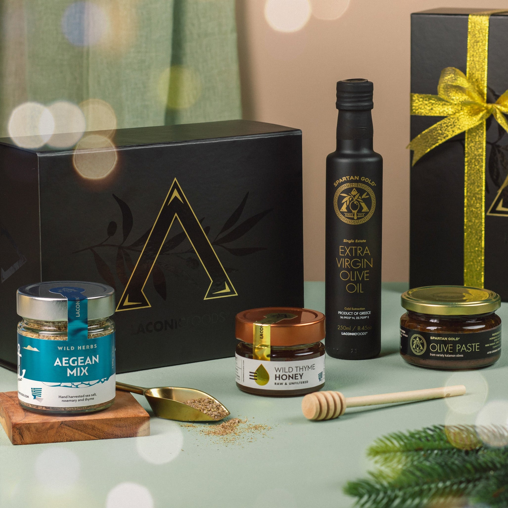 Festive Laconic Foods holiday gift box featuring Greek olive oil, honey, olive paste, and Aegean spice blend with ribbon and holiday decor