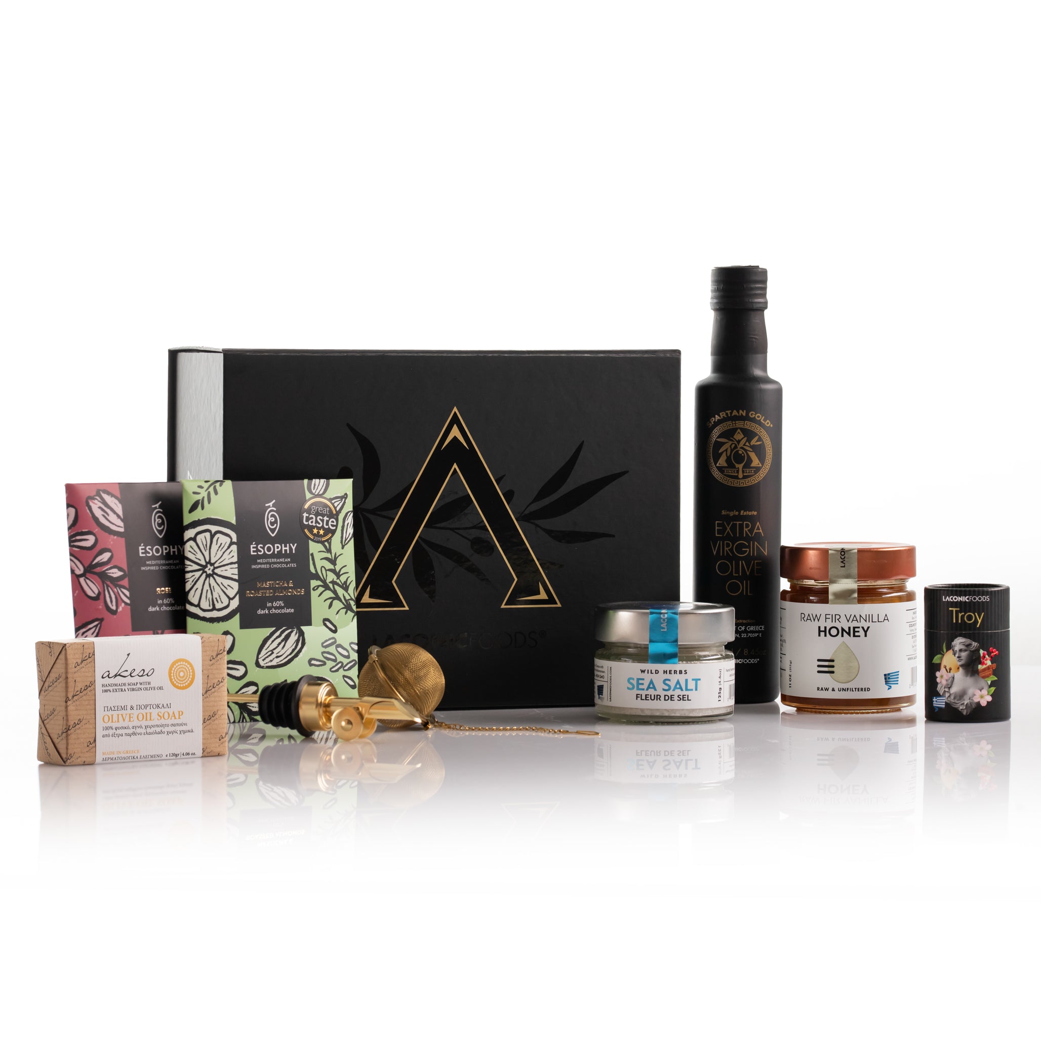 Laconic Foods Greek gourmet gift set display with EVOO, raw honey, handmade chocolates, fleur de sel, mini tea, olive oil soap, pourer, and tea infuser