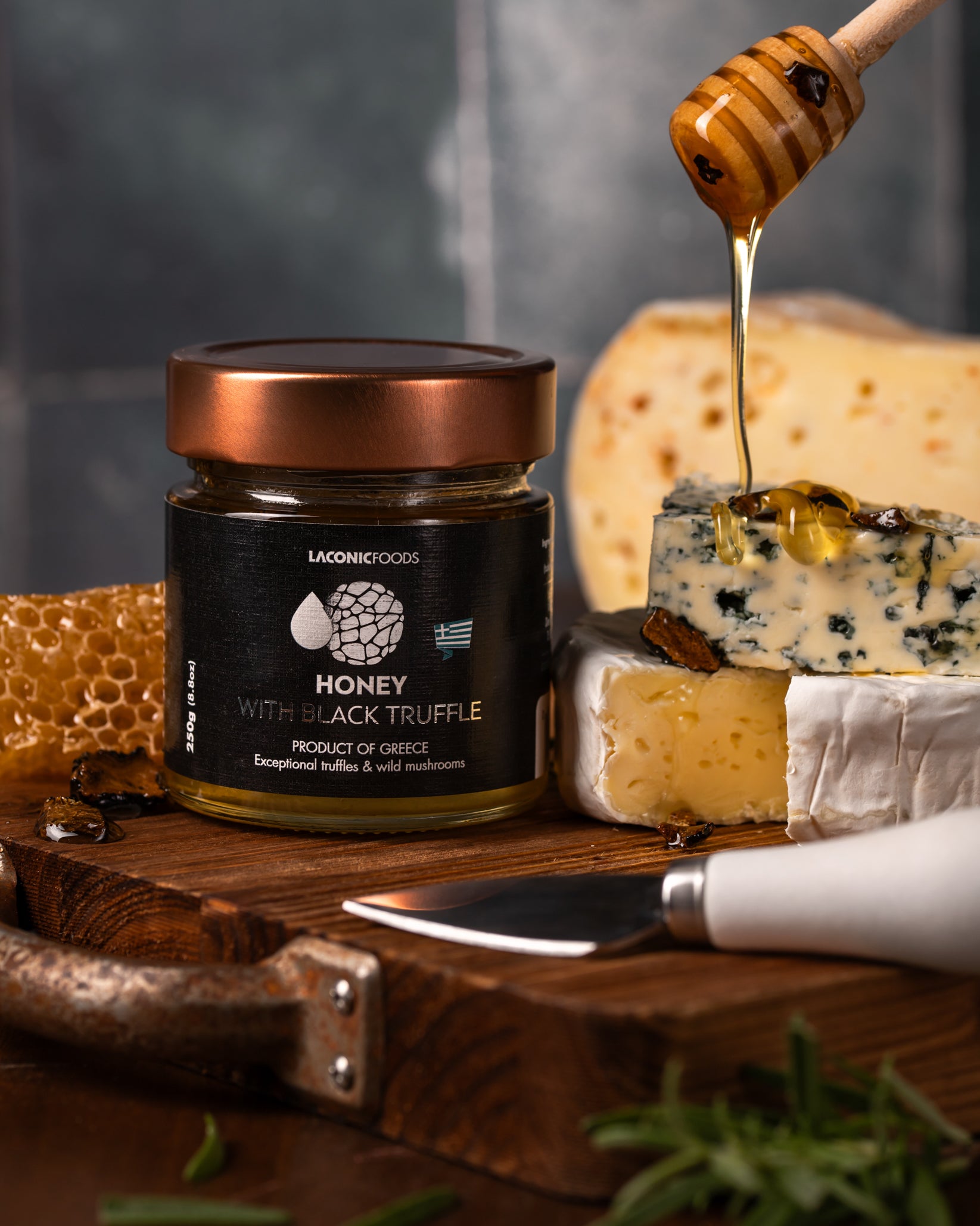 Laconic Foods Honey with Black Truffle 250g paired with gourmet cheeses, honey drizzle, and truffle pieces – elegant serving suggestion from Greece.