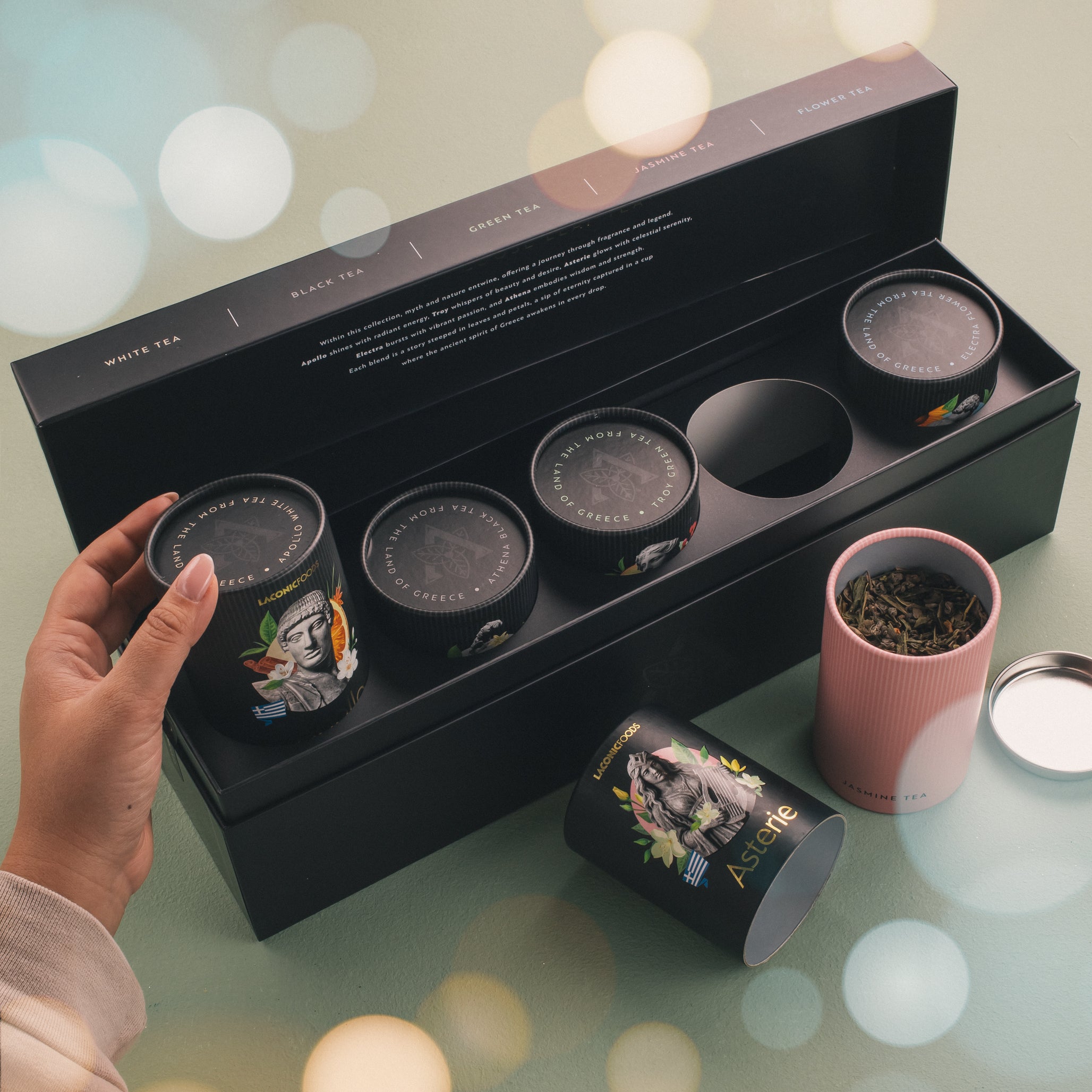 Lifestyle image of Laconic Foods premium loose leaf tea gift set with open tins, loose tea leaves, and luxury presentation box