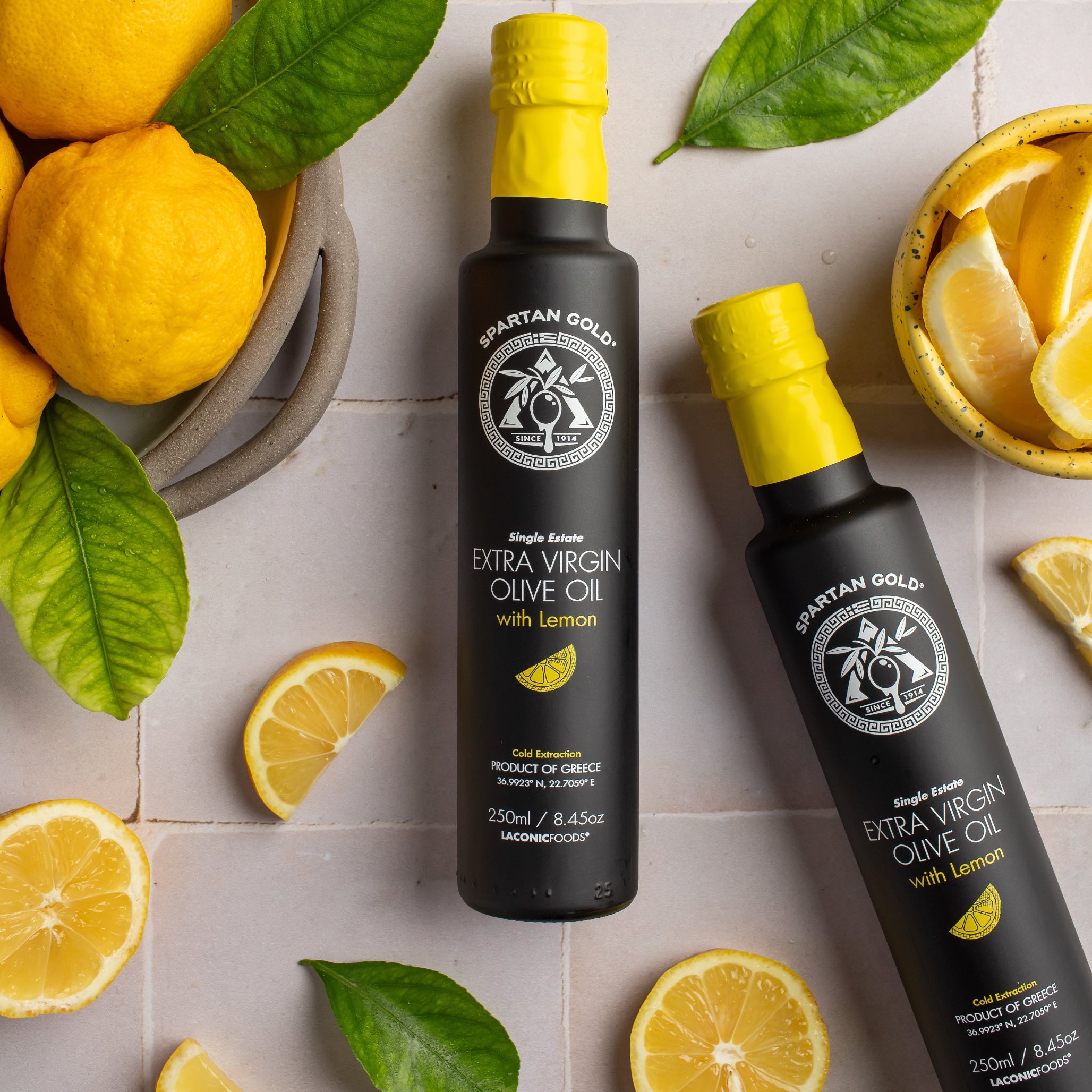 Overhead flatlay of lemon infused EVOO bottles surrounded by fresh lemons and leaves