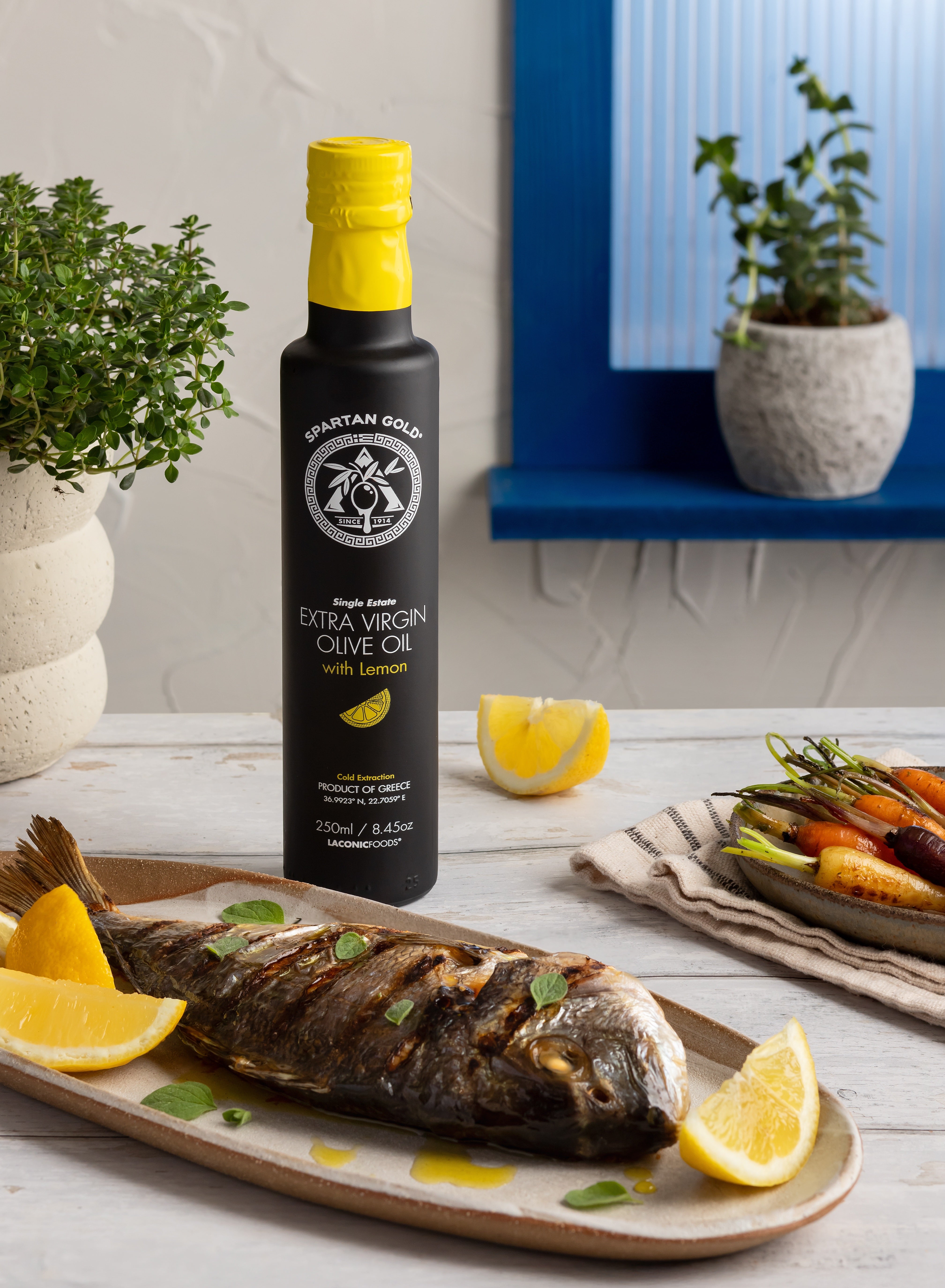 Lemon infused olive oil with grilled fish, lemon wedges, and vegetables in a Mediterranean kitchen setting