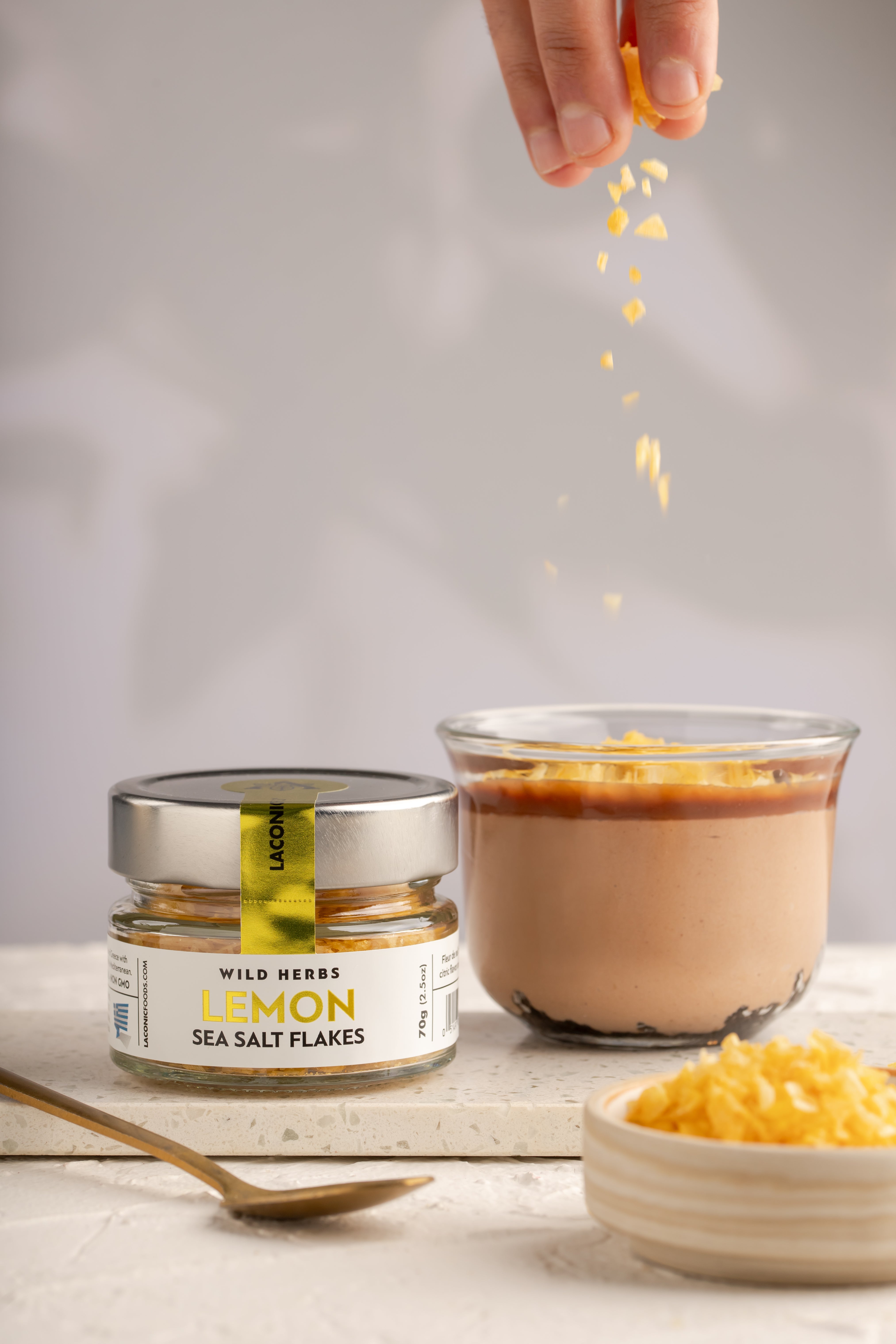 Lemon Sea Salt Flakes being sprinkled over a citrus dessert for a gourmet finishing touch