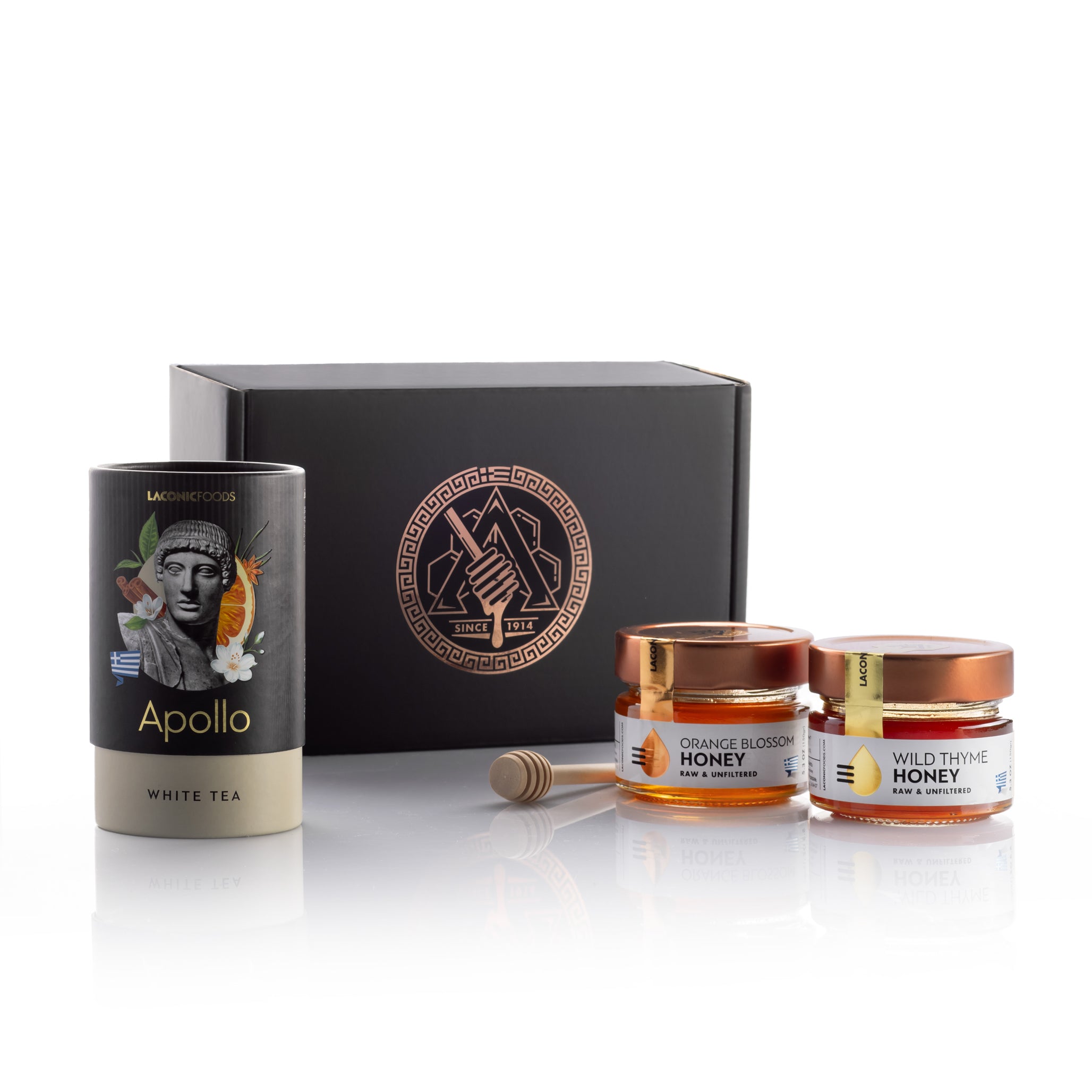 Laconic Foods Greek tea and honey gift set displayed with Apollo white tea, raw Greek honey jars, honey dipper, and premium black gift box