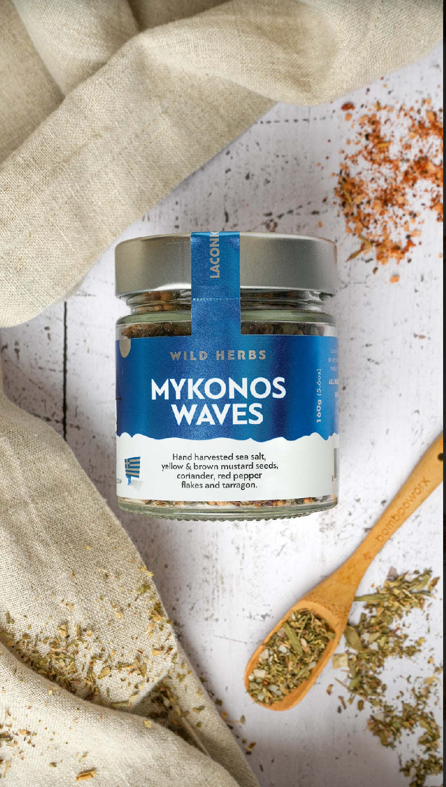 Top-down view of Mykonos Waves herb blend with sea salt, red pepper, and tarragon scattered on rustic surface
