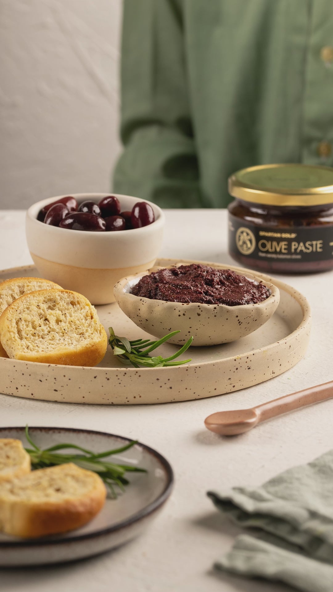 Video of Laconic Foods Kalamon olive paste being spread onto a piece of traditional Greek rusk.